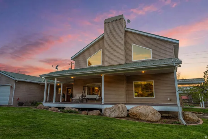 Two-story residence featuring light brown siding and a green metal roof