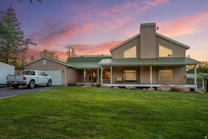 Spacious residence featuring a metal roof, attached garage, and a covered front porch