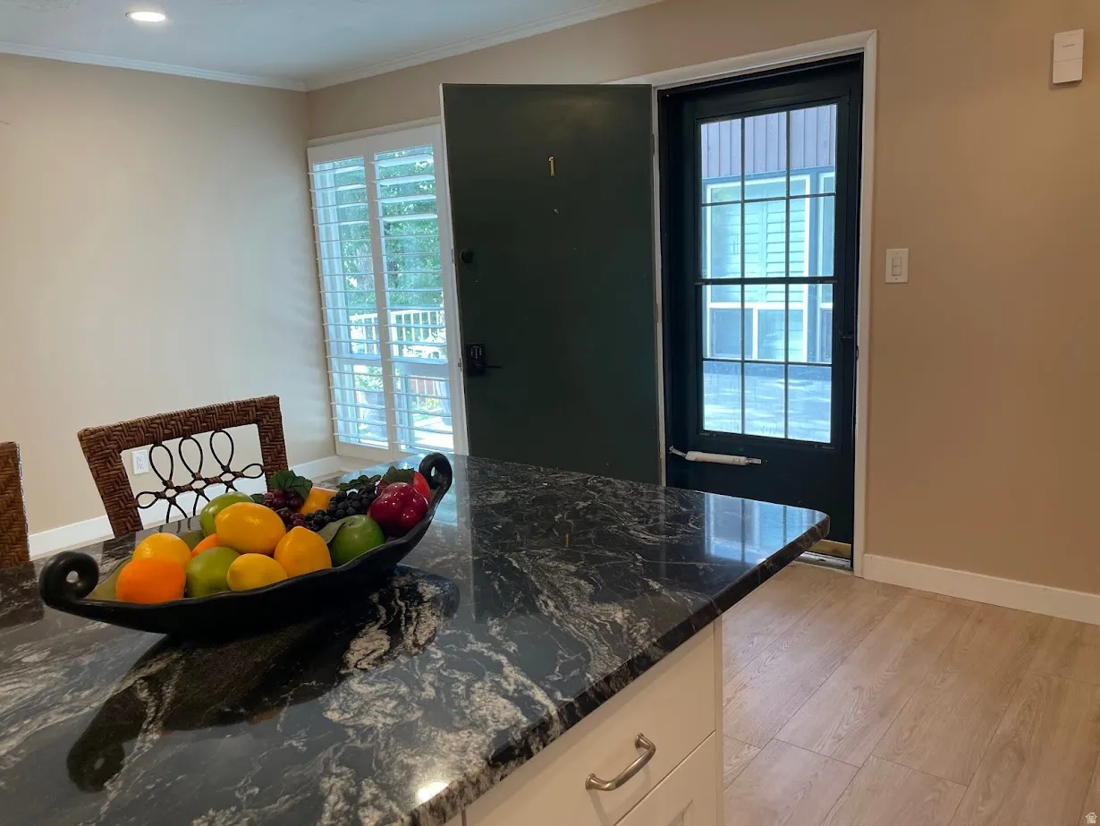 Kitchen island with a dark granite-style countertop and light-colored cabinetry