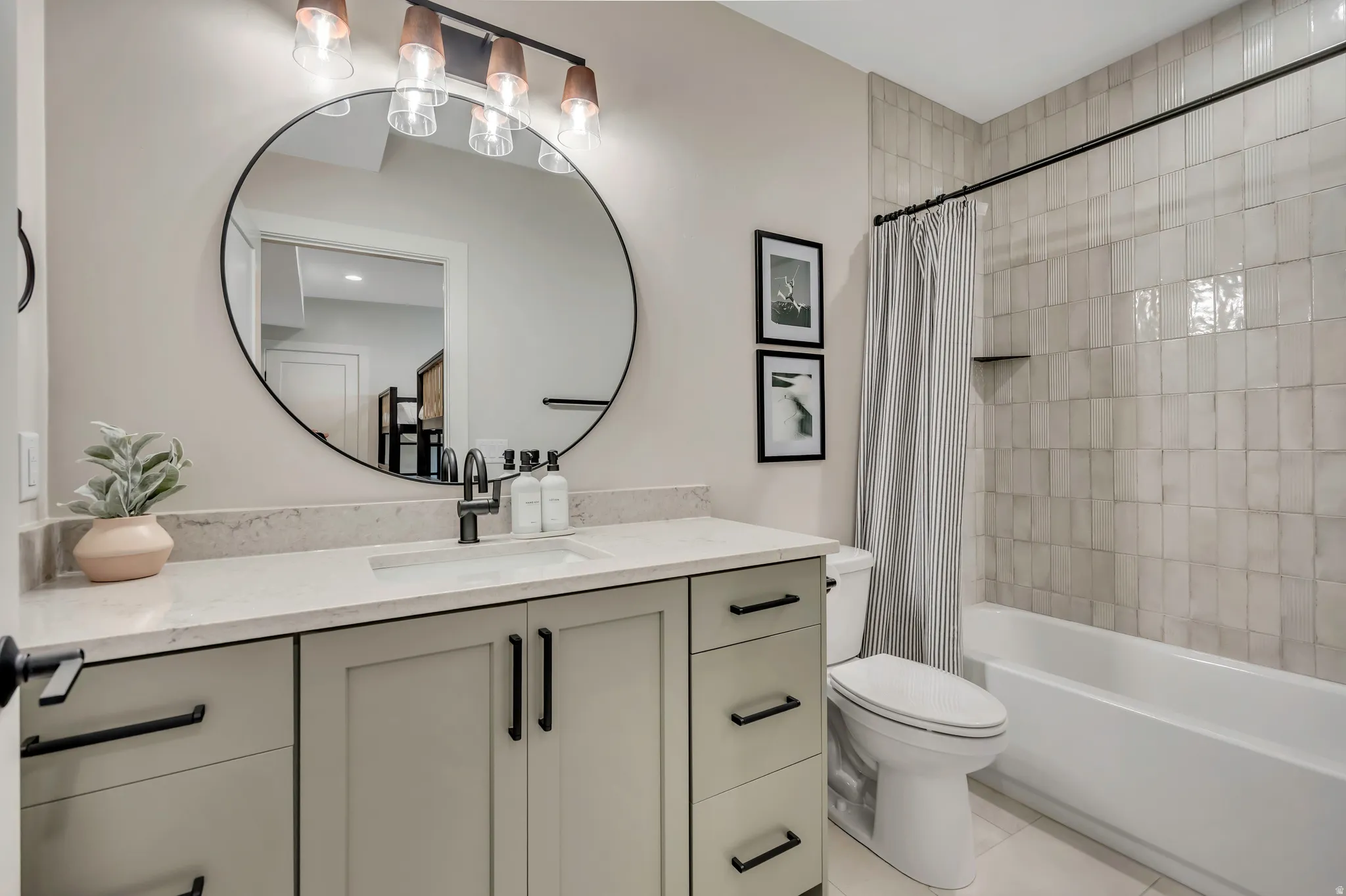 Full bathroom with vanity, shower / bath combo with shower curtain, and light tile patterned flooring
