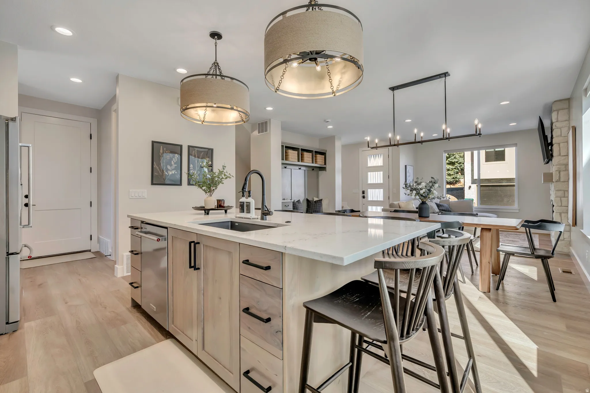 Kitchen featuring light wood-type flooring, light wood finish cabinetry, light stone counters, a spacious island, and open floor plan
