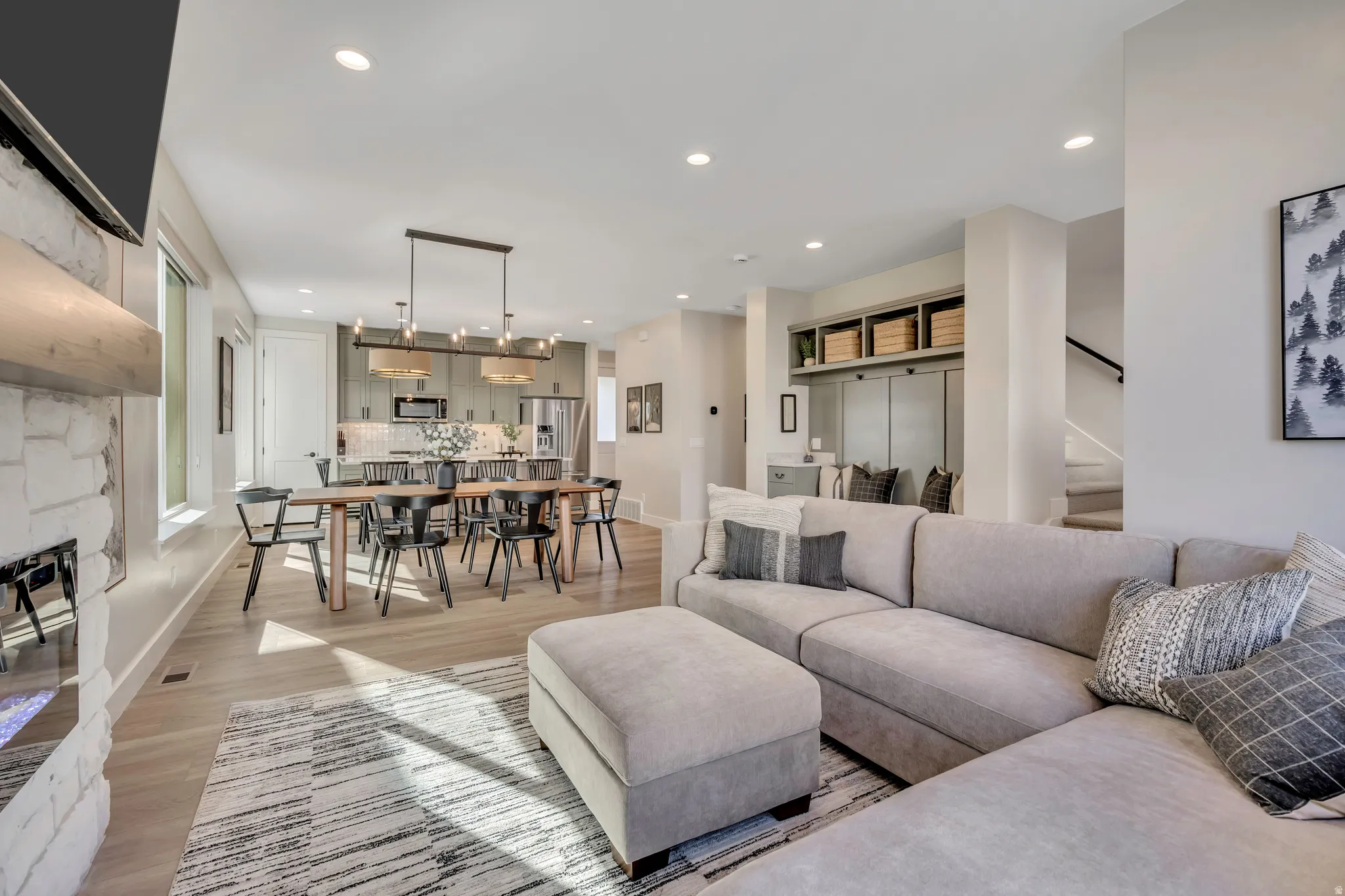 Living room featuring light wood-style floors, recessed lighting, and a stone fireplace