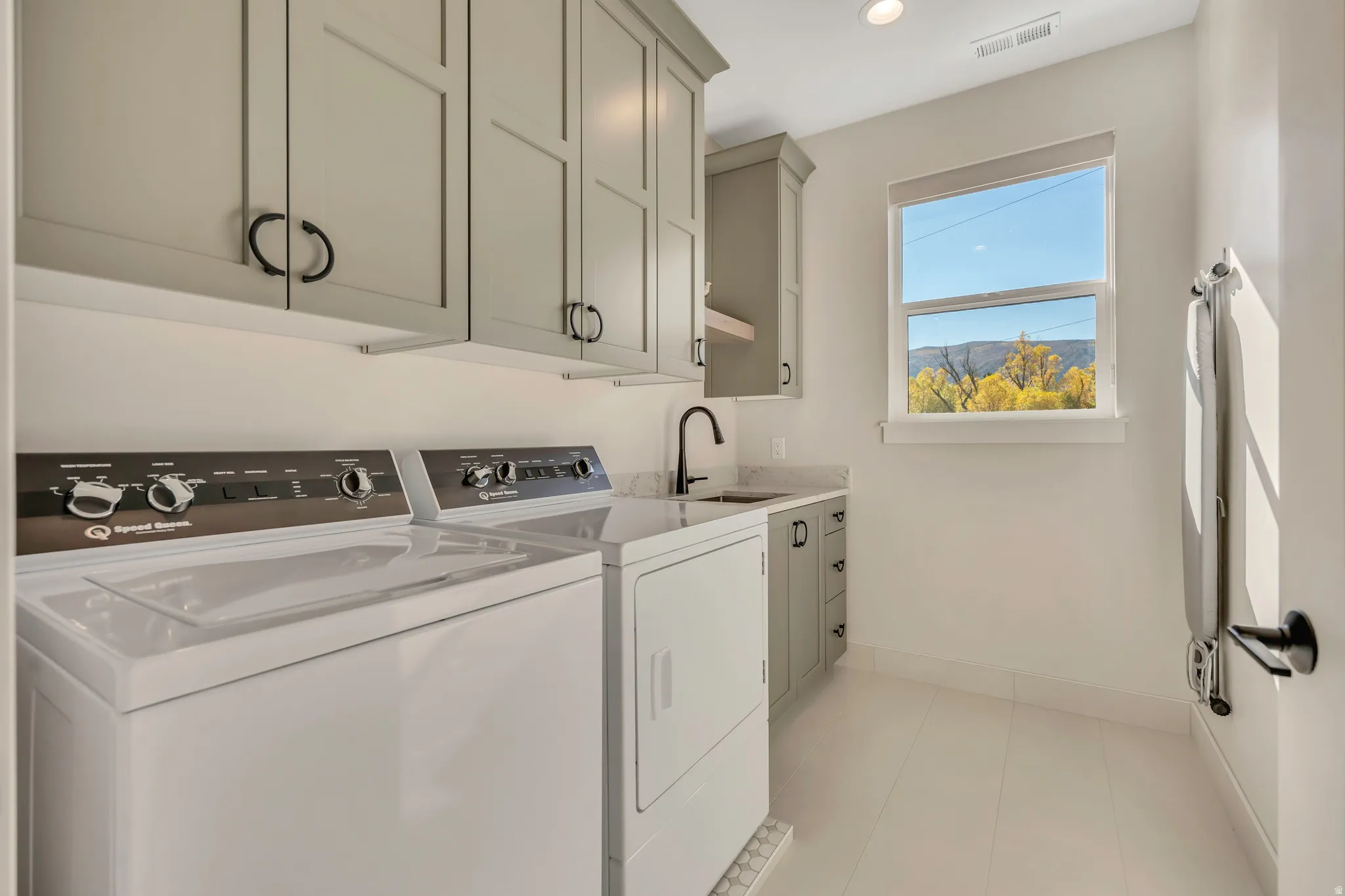 Laundry room featuring cabinet space, washer and clothes dryer, recessed lighting, and light tile patterned floors