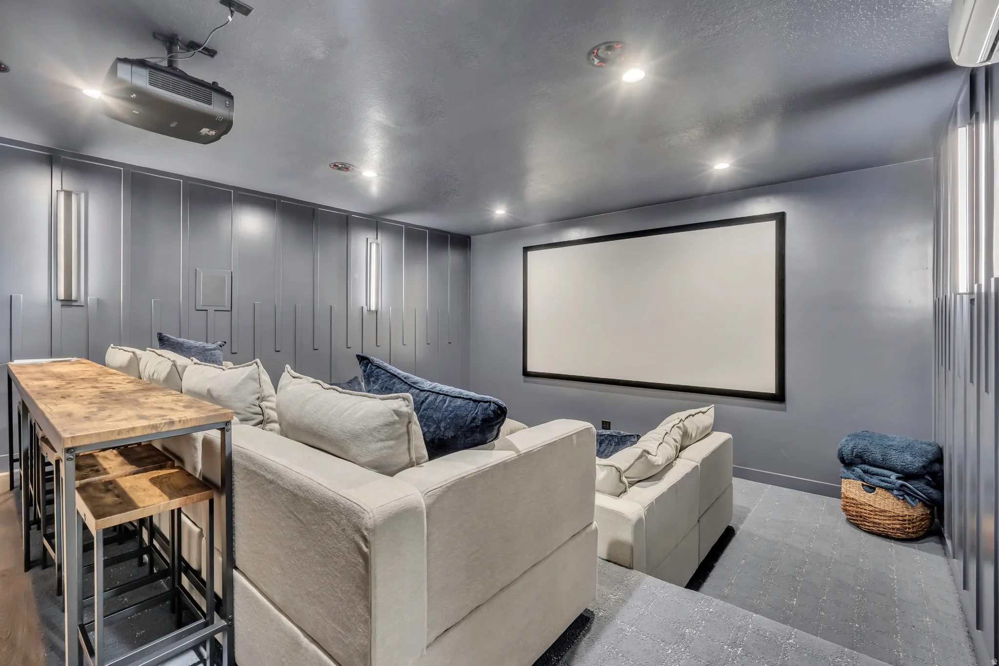 Home theater room featuring a decorative wall, recessed lighting, and a textured ceiling