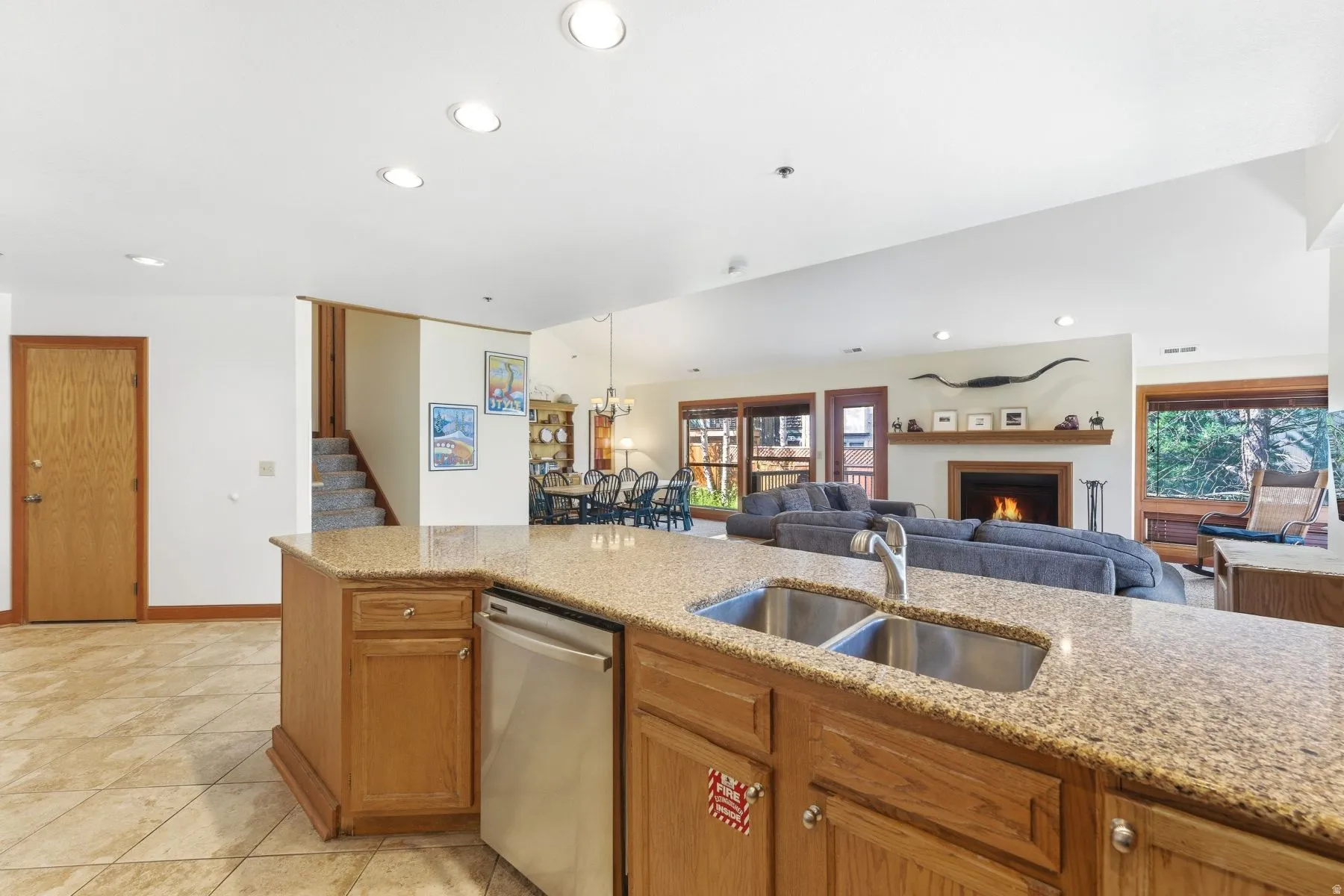 Kitchen island featuring a double basin stainless steel sink, pull-down faucet, and integrated dishwasher