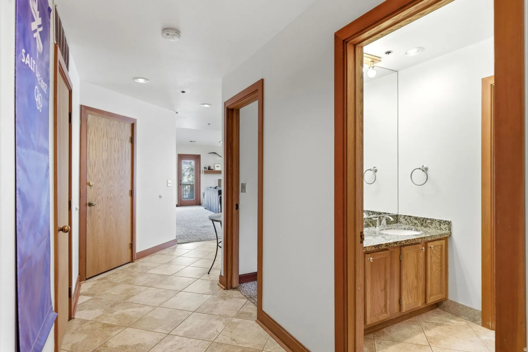 Entryway featuring diagonally laid tile flooring, warm wood trim, and multiple doorways