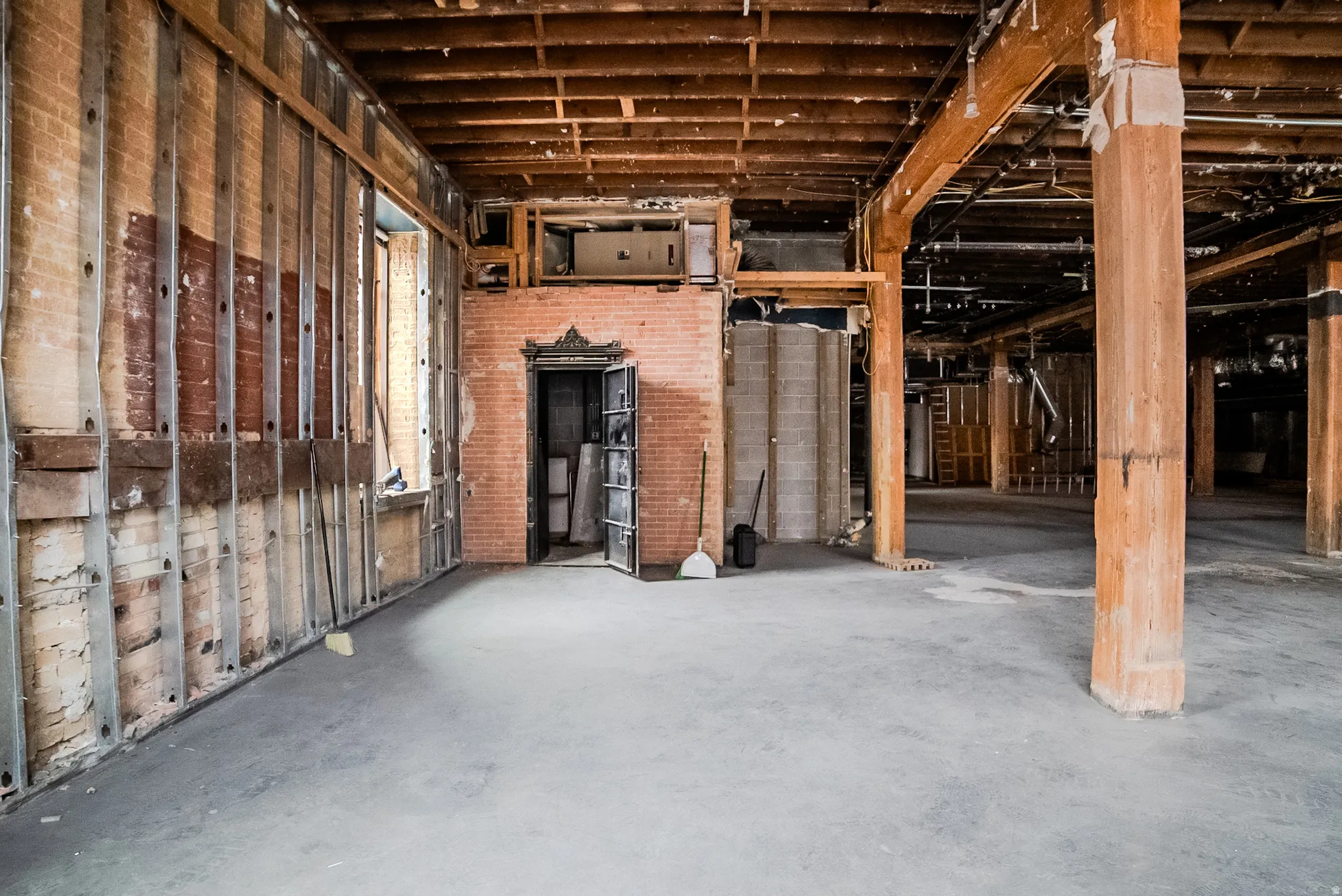 Misc room featuring unfinished concrete flooring and brick wall