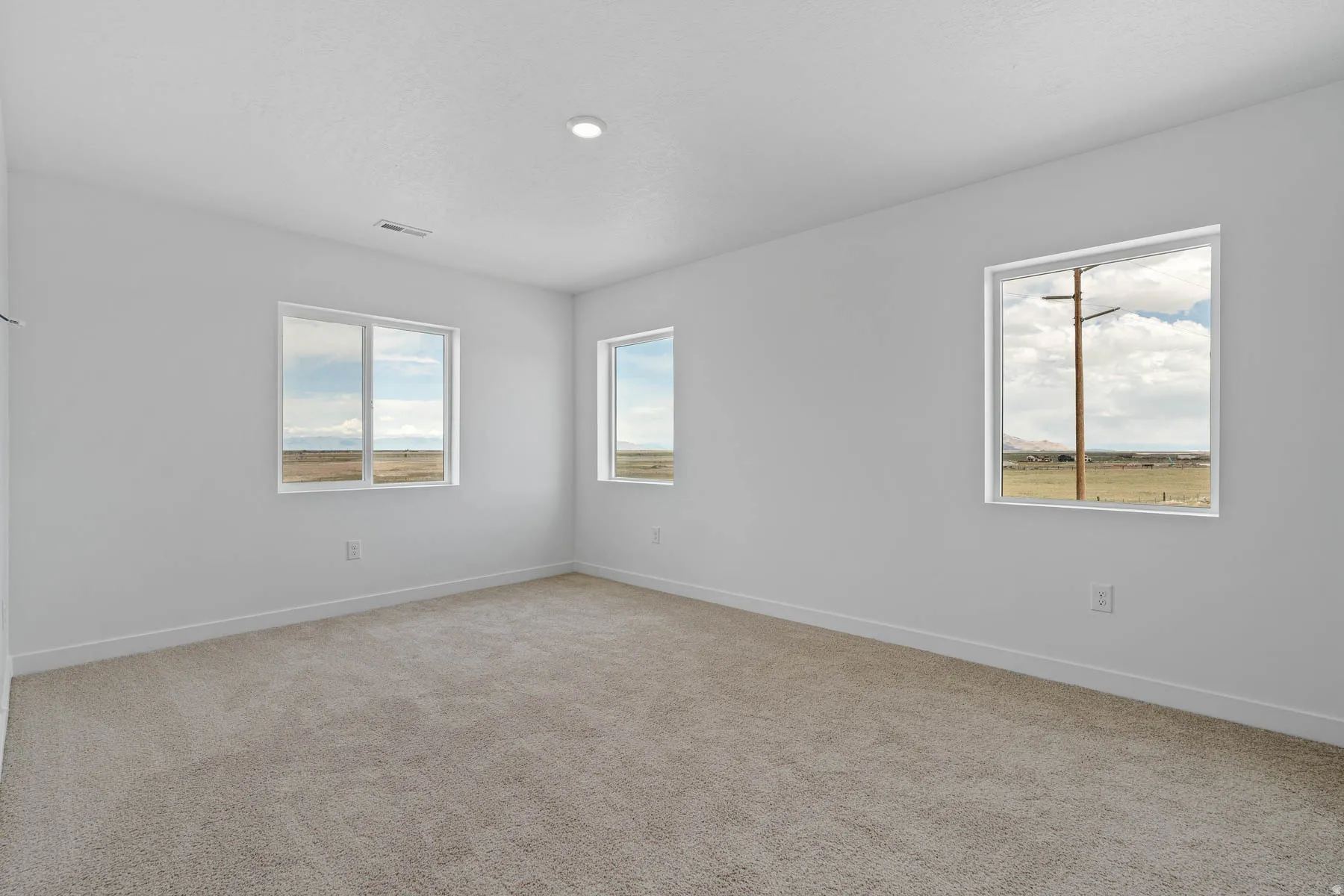 Spacious room featuring neutral carpeting and white painted walls