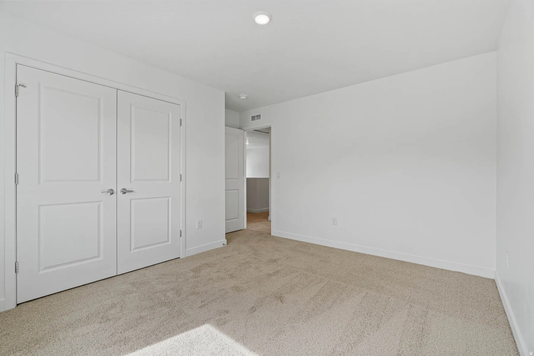 Room featuring light-toned carpet flooring, white walls, and white baseboards