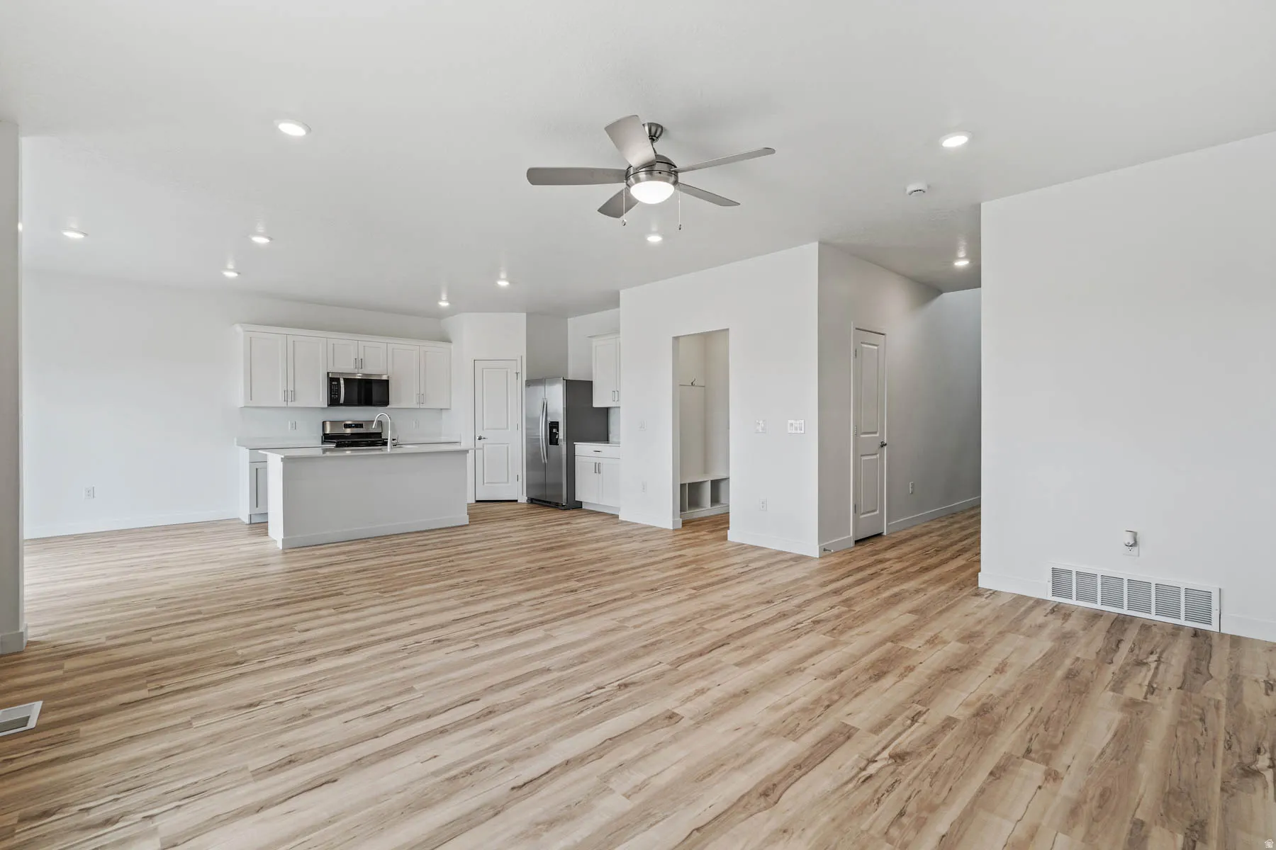 Spacious living area featuring wood-finish flooring and recessed lighting