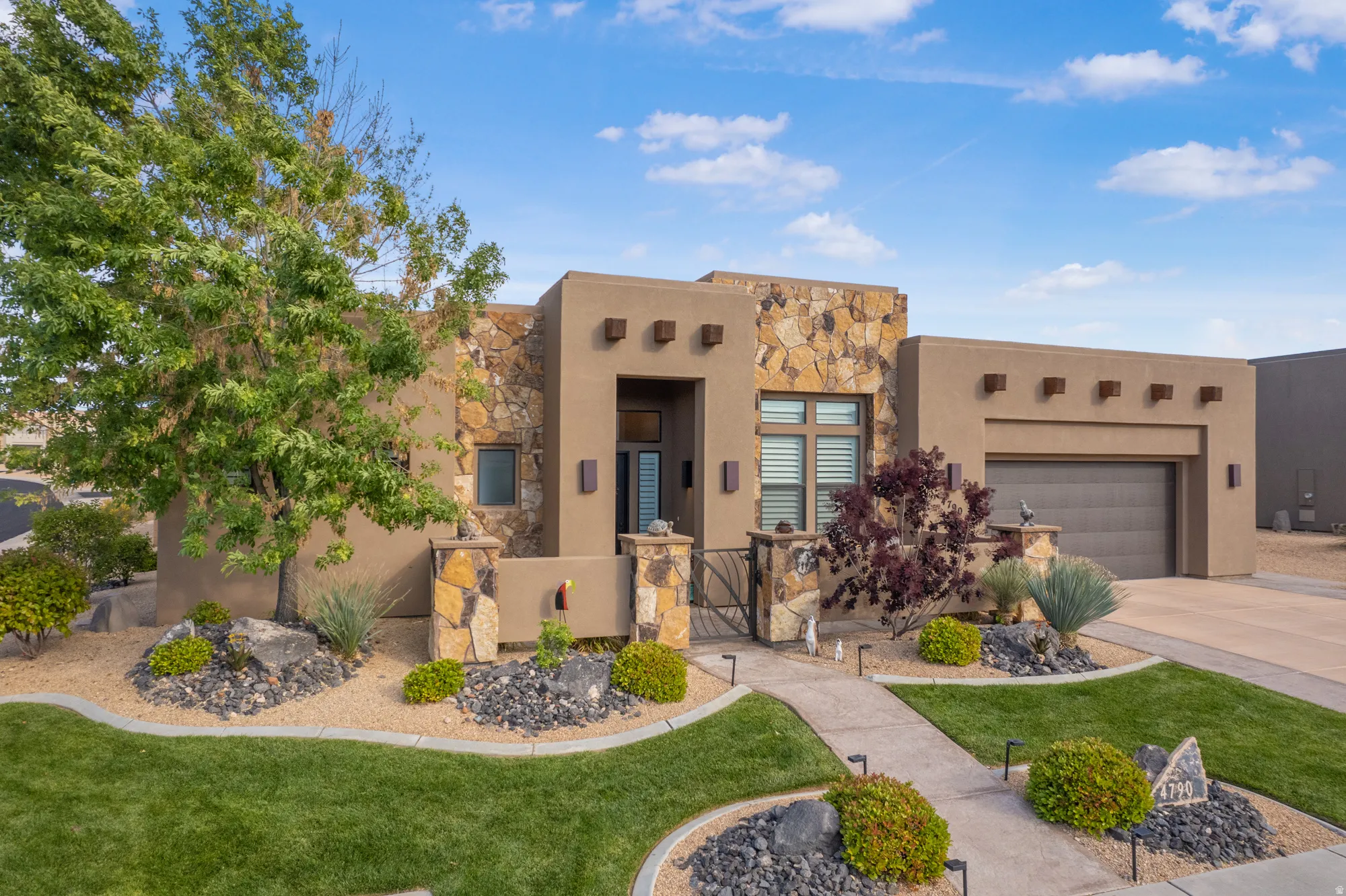 Southwestern-style residence featuring stucco and stone veneer exterior