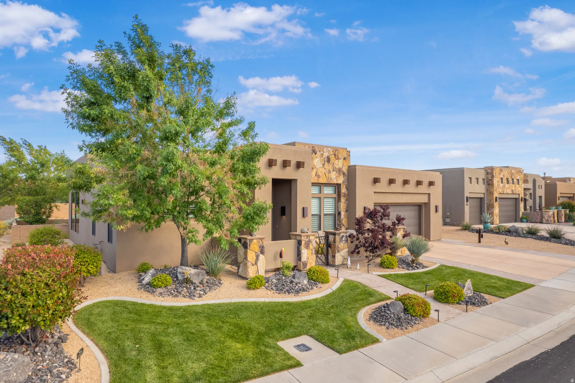 Stucco exterior with stone accents and an integrated two-car garage