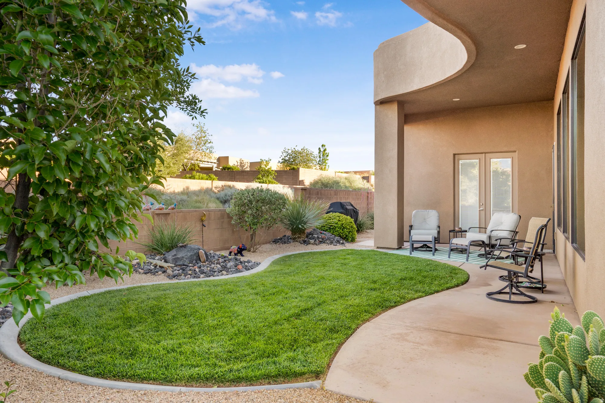 Outdoor patio featuring a stucco exterior, double glass doors, a curved covered ceiling, and recessed lighting