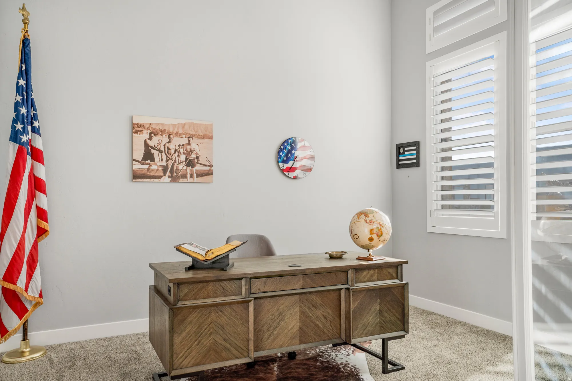 Light gray walls featuring a wide window with white plantation shutters