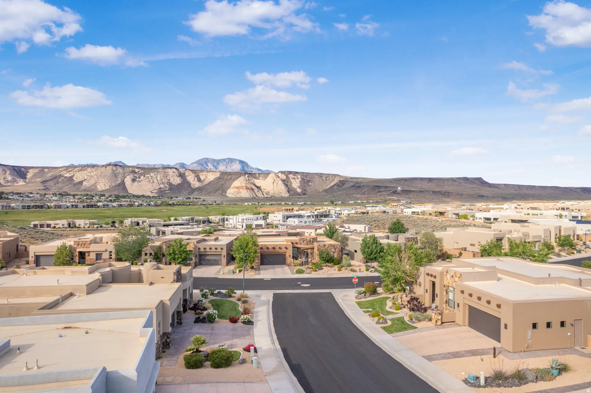 Desert landscape with a residential neighborhood featuring stucco homes and paved streets