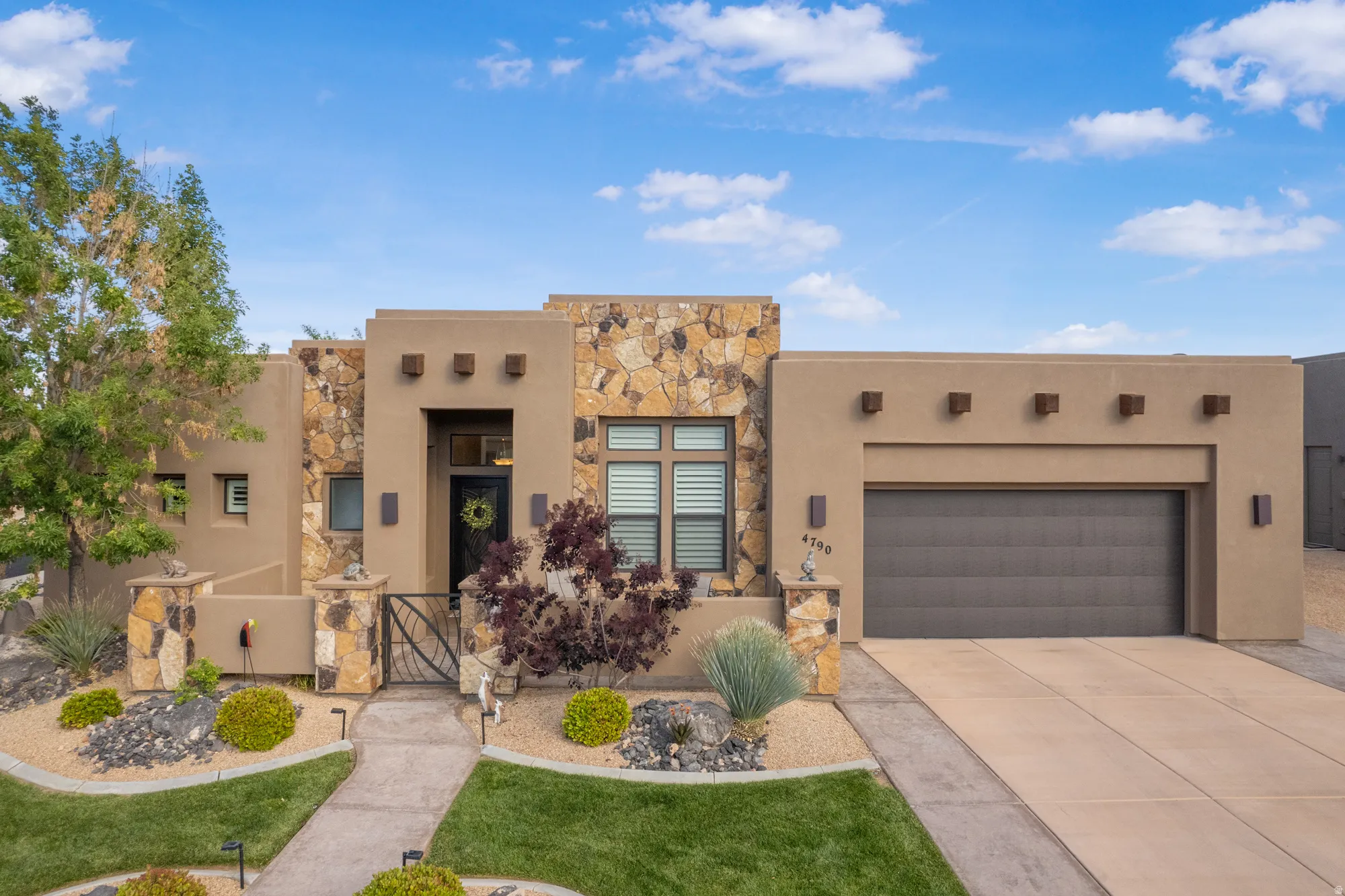 Southwestern-style exterior featuring stucco and natural stone accents