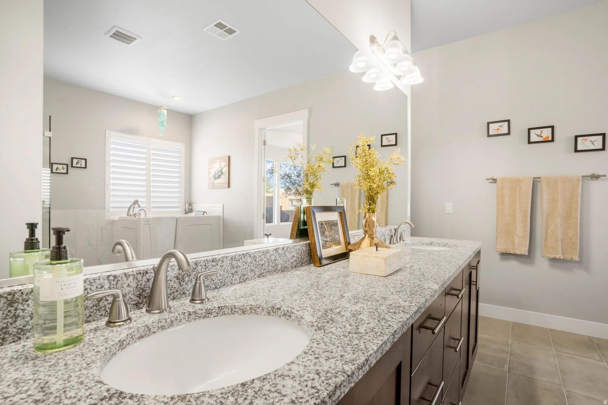 Dual undermount sinks with brushed nickel fixtures set into a speckled stone countertop