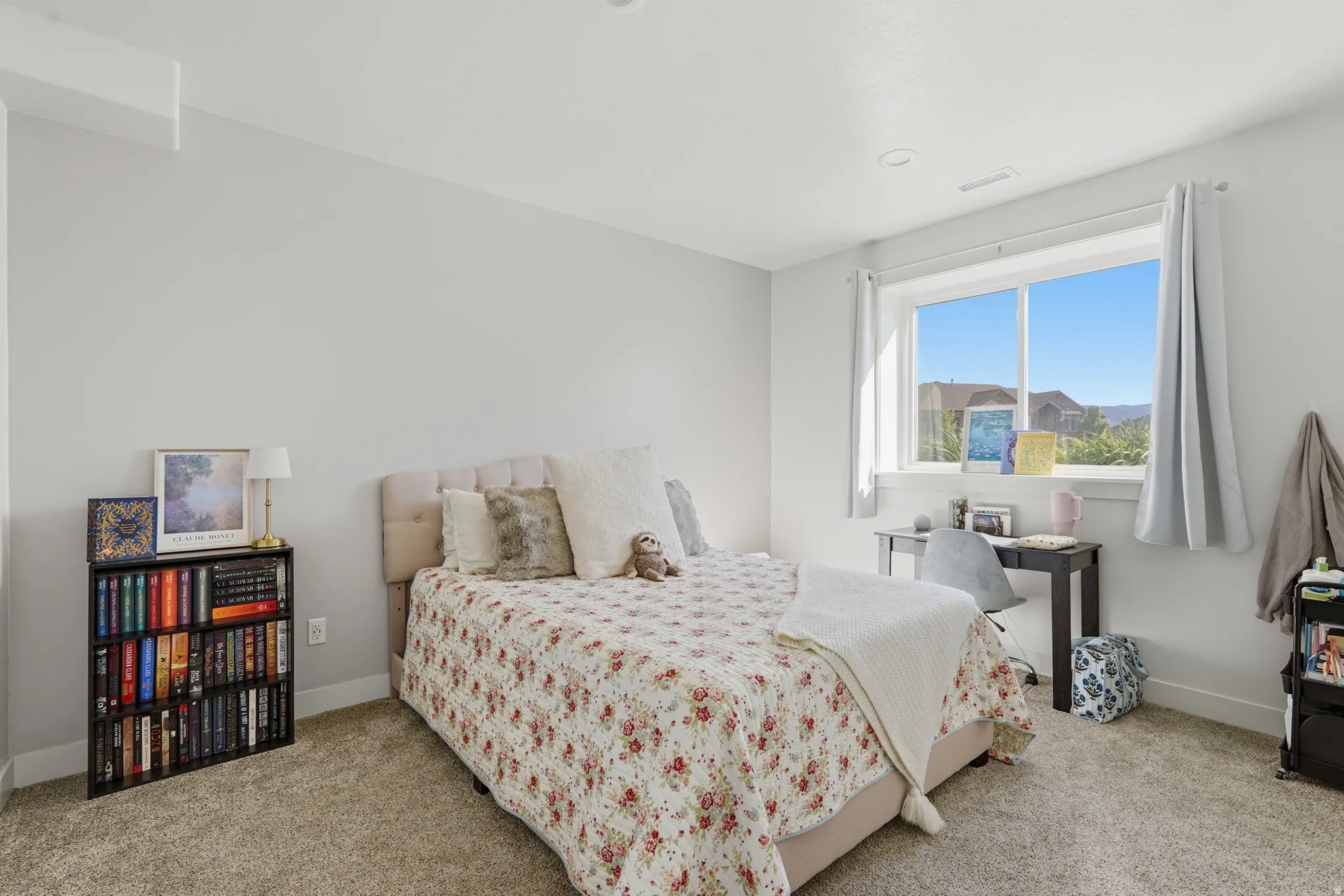 Bright bedroom featuring a large window, neutral wall paint, recessed lighting, and carpeted flooring