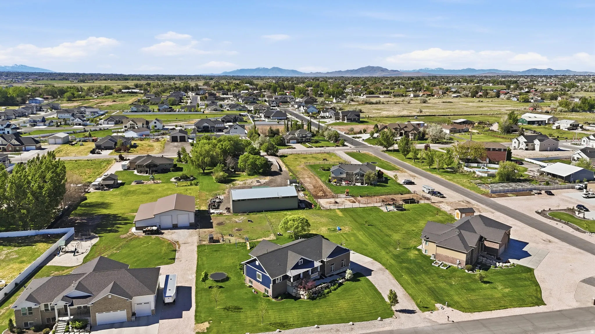 Expansive lot featuring a large blue residence with a dark roof