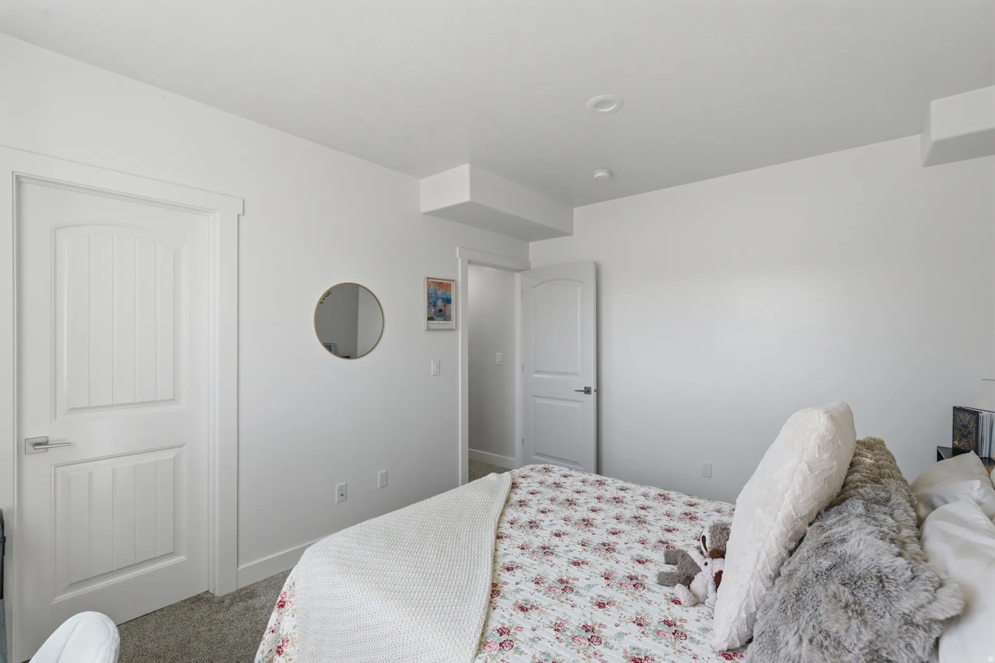 Bright interior room featuring a recessed ceiling light, white paneled doors, and light gray carpet