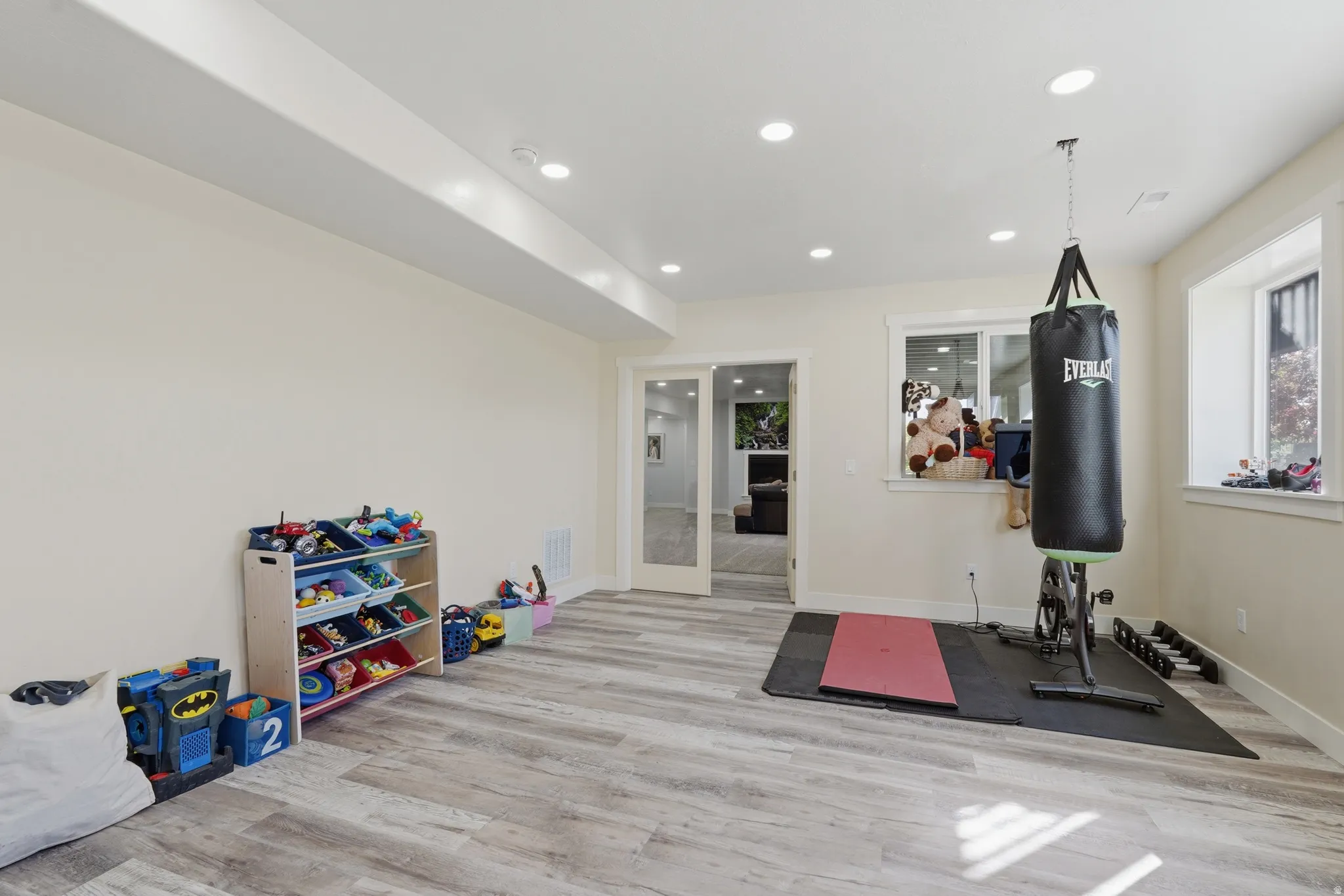 Spacious room featuring wood-finish flooring, recessed lighting, and a neutral color palette