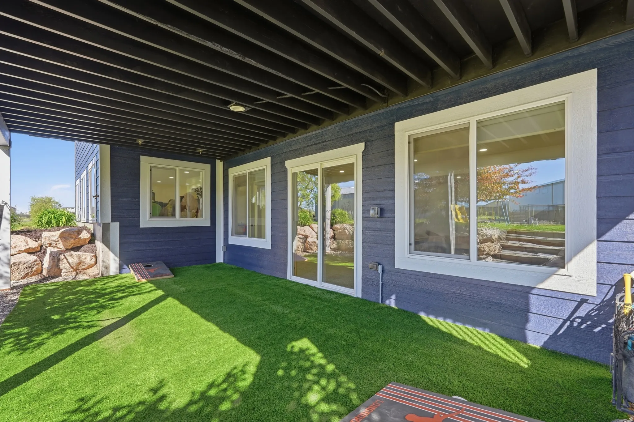 Covered patio area featuring synthetic turf flooring