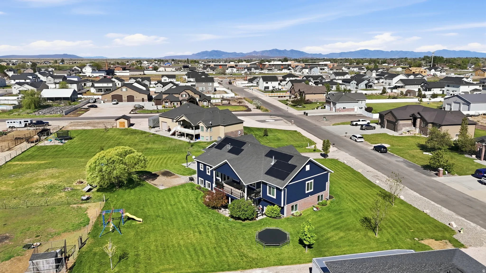 Blue-sided residence featuring a dark roof with solar panels