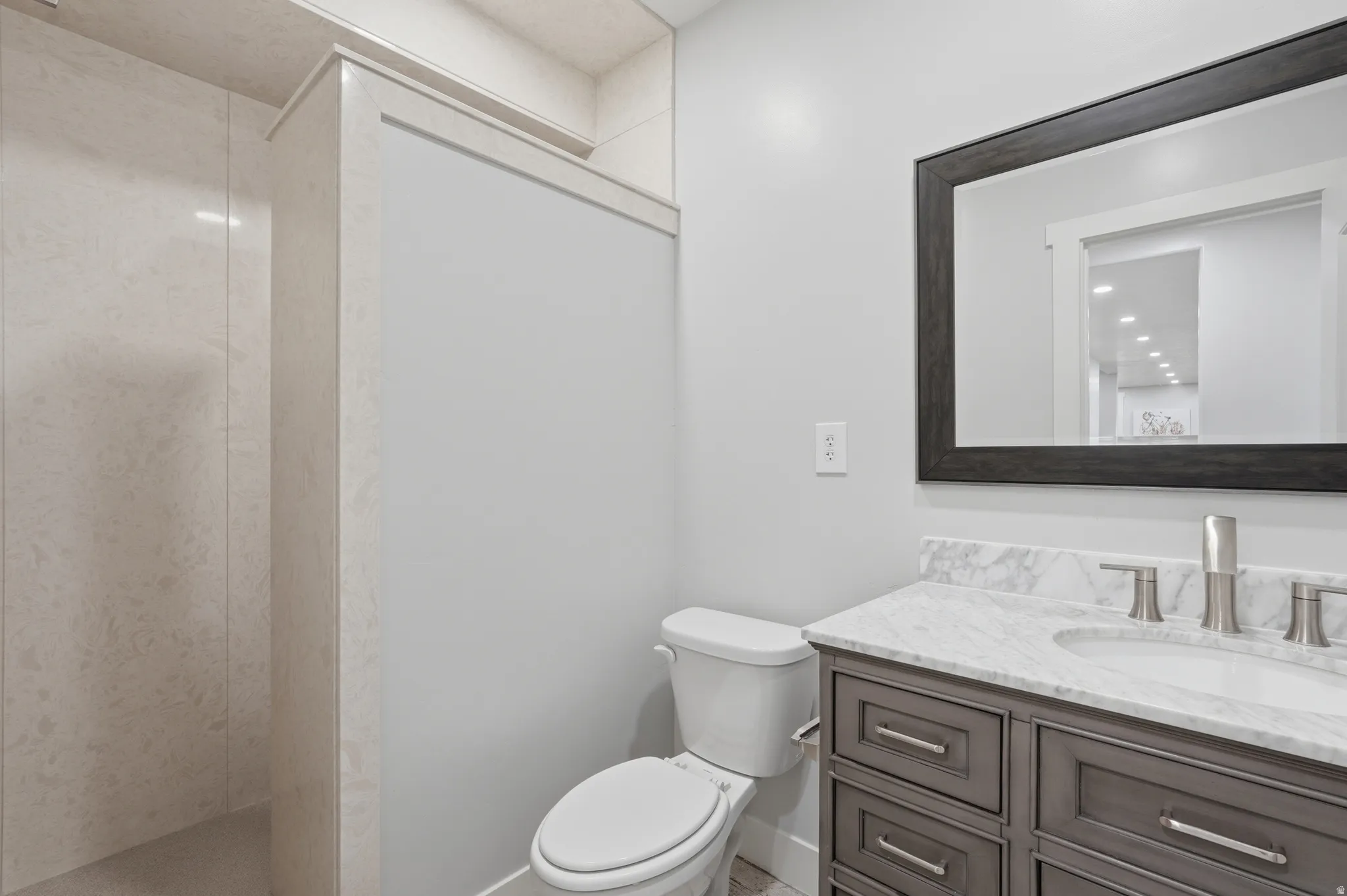 Bathroom featuring a single vanity with gray cabinetry, a white countertop, and a rectangular undermount sink