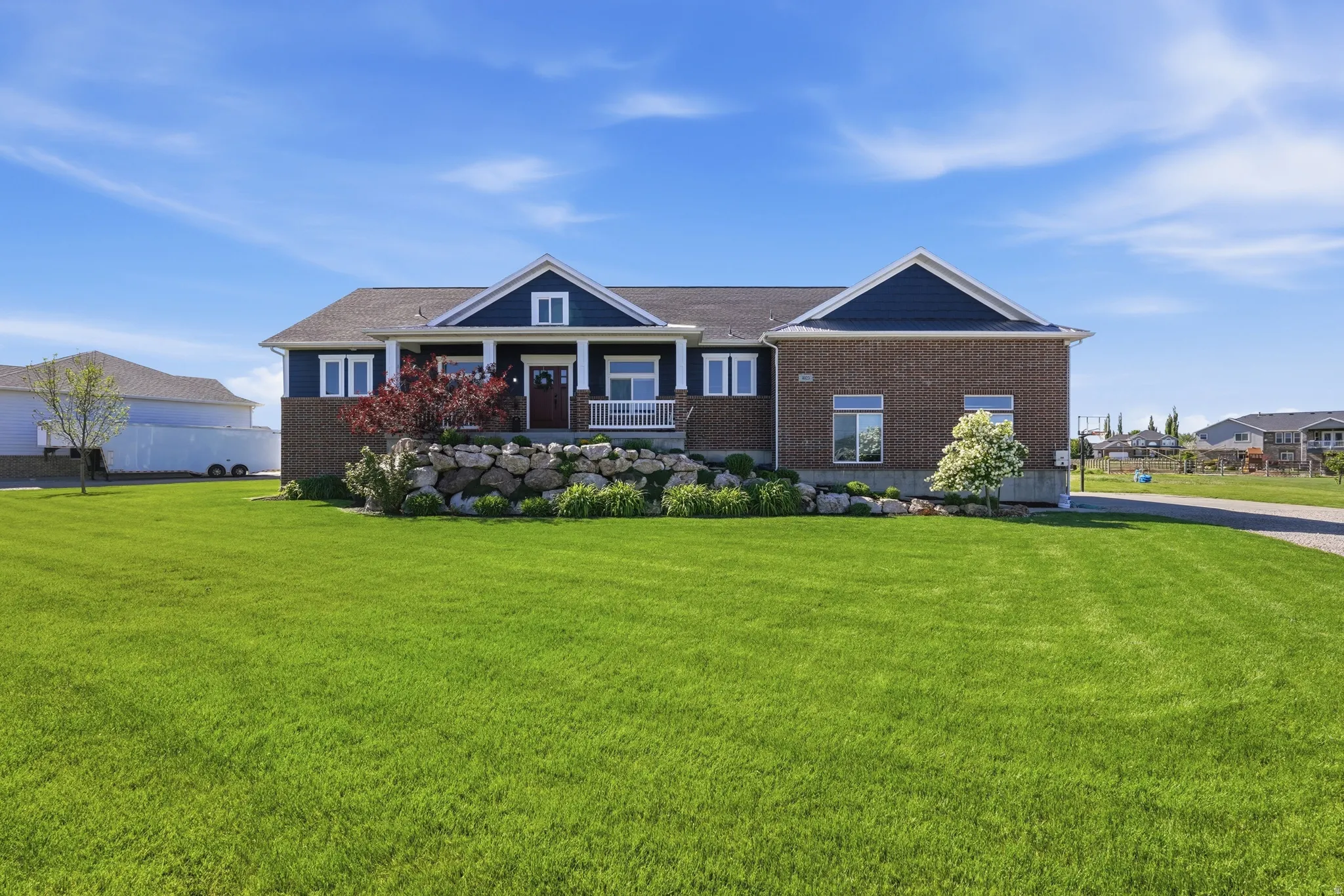 Exterior showcasing brick and dark blue siding accents