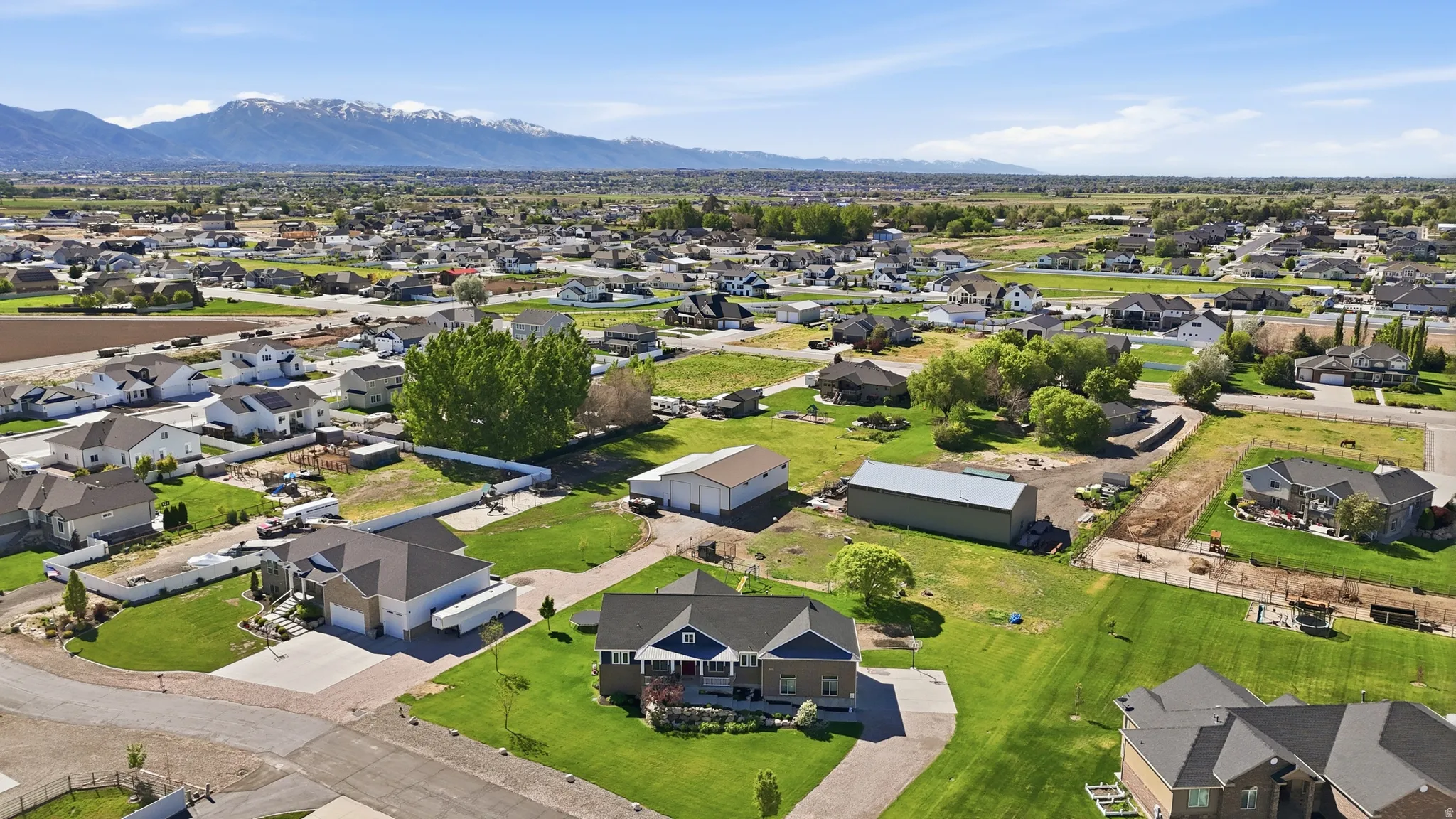 Expansive aerial perspective showcasing a residential community with distant snow-capped mountains