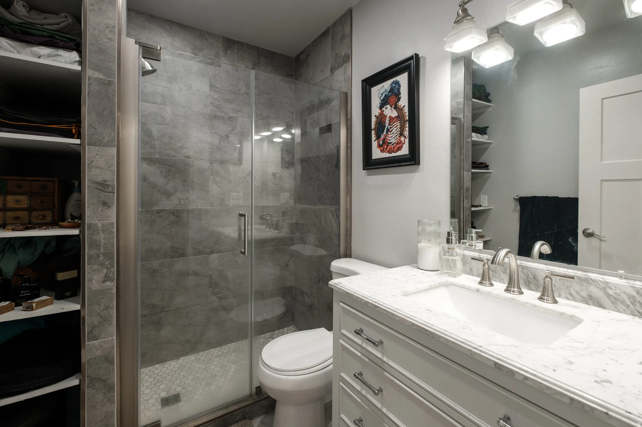 Contemporary bathroom featuring a frameless glass shower enclosure with large format grey tile surround and a mosaic tile pan
