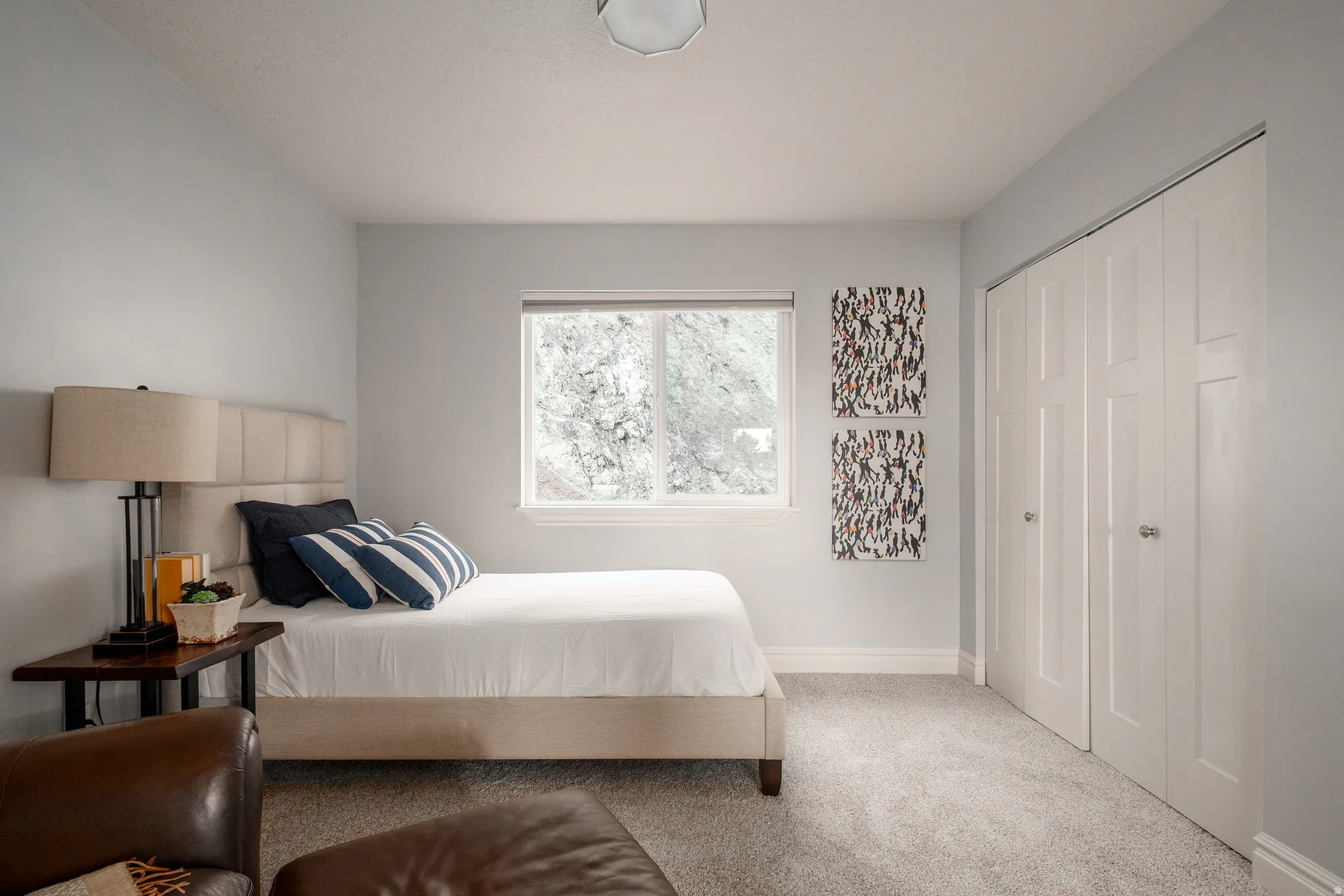 Carpeted room featuring a single window, white trim, light gray walls, and bi-fold closet doors
