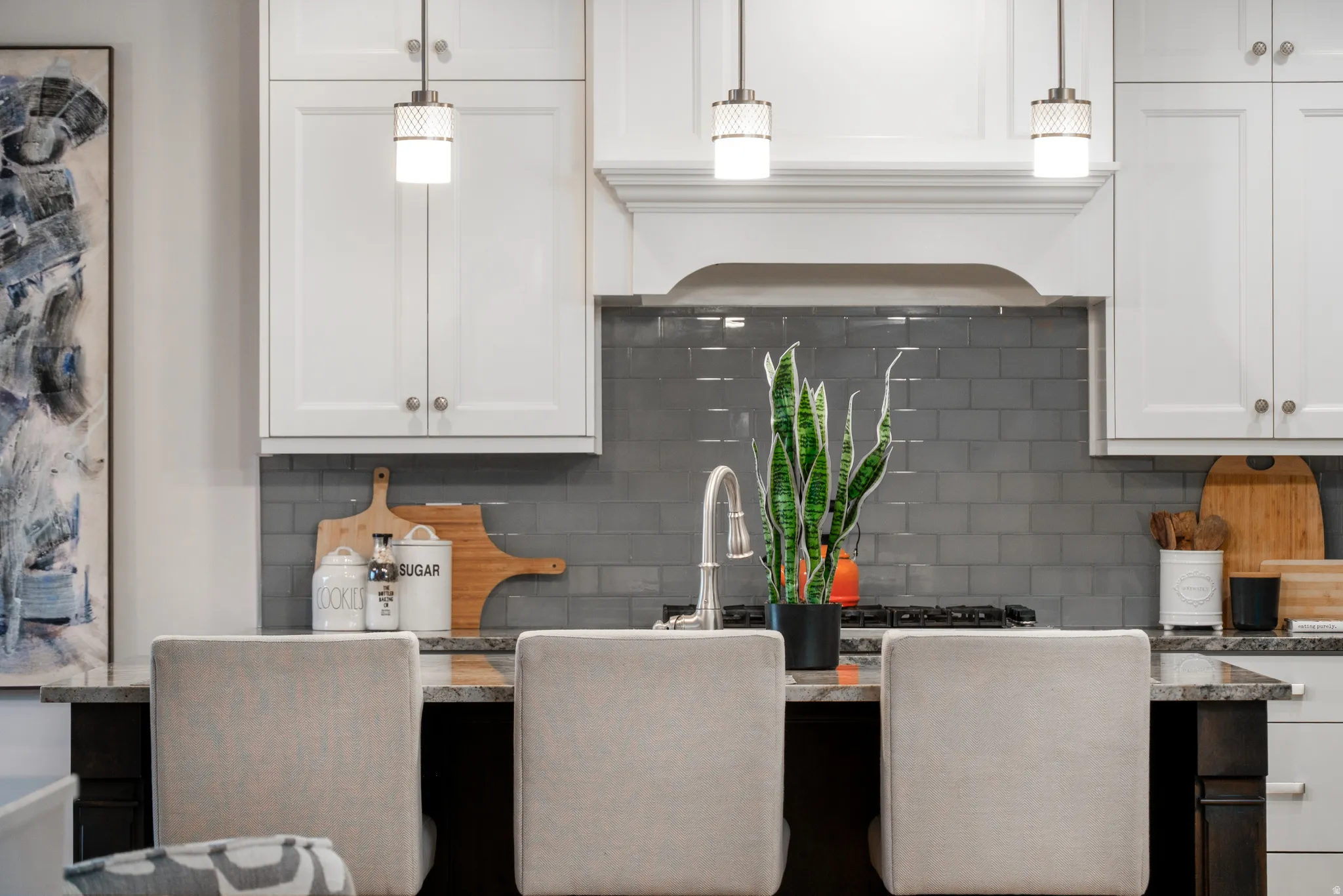 Kitchen featuring white cabinetry, grey subway tile backsplash, and dark countertop