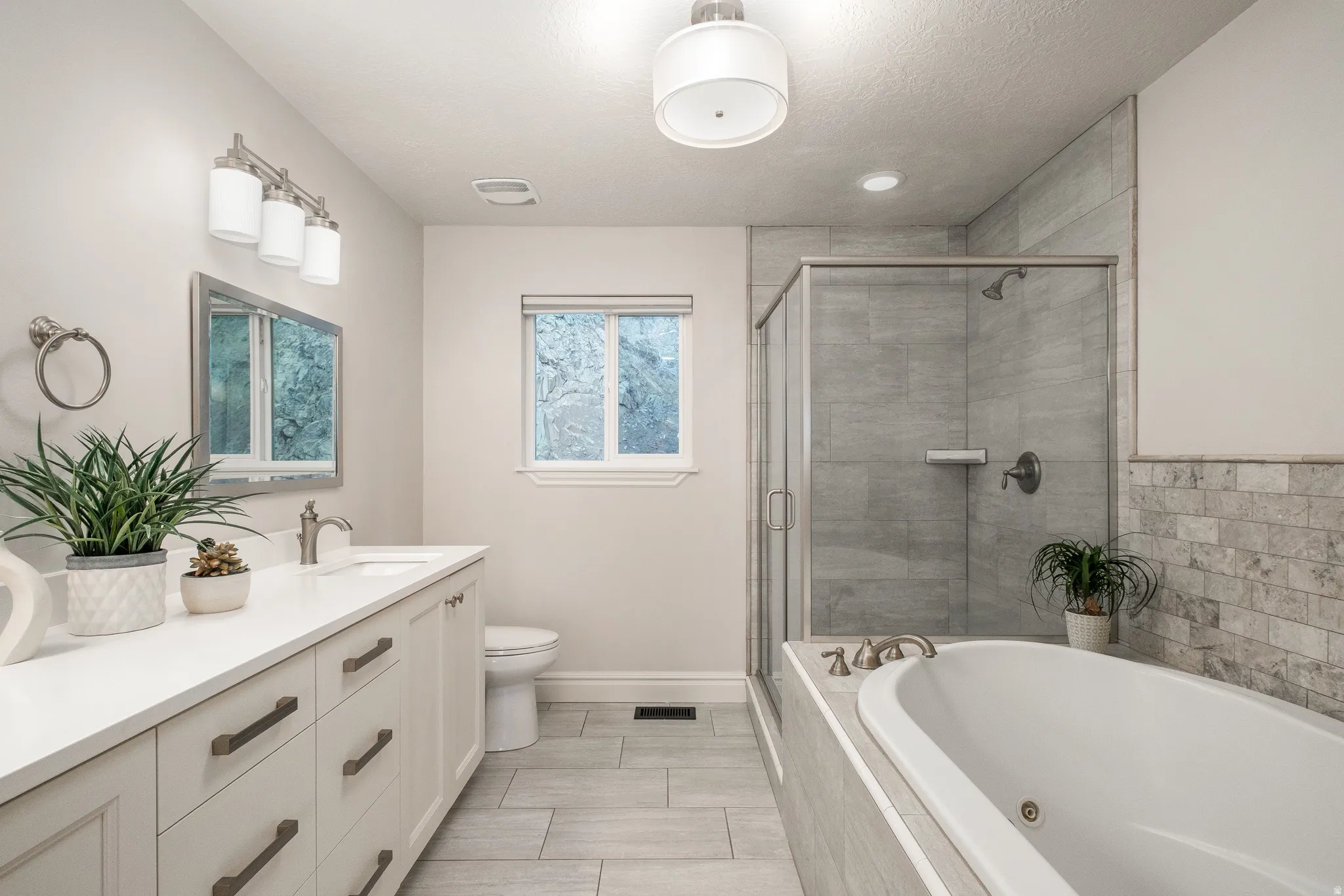 Contemporary bathroom featuring a white vanity with multiple drawers, a rectangular undermount sink, and a framed mirror