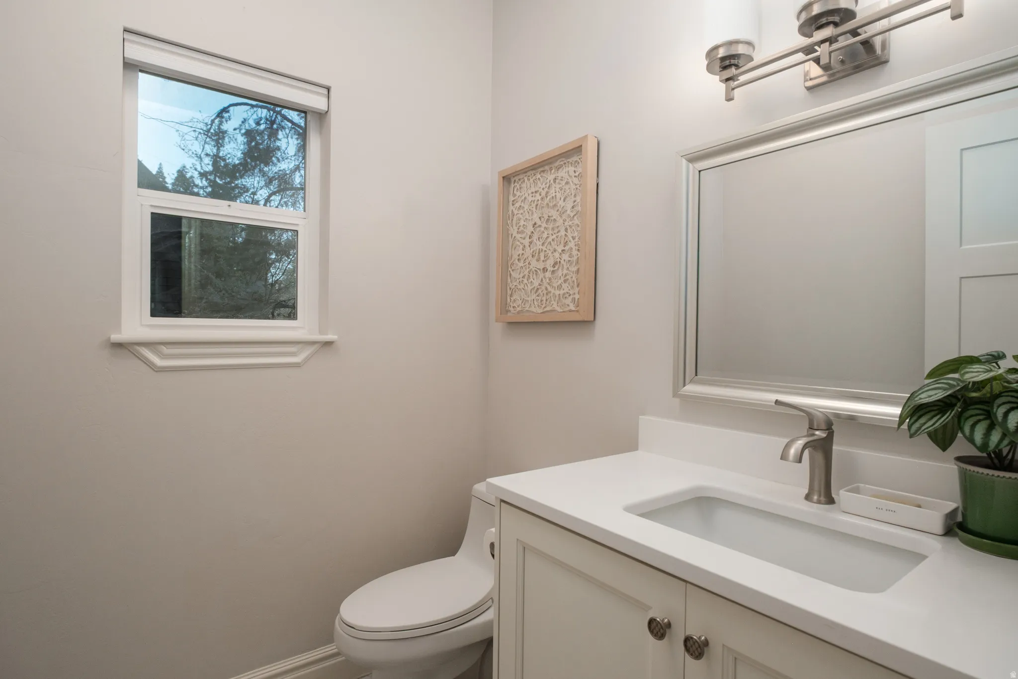Bathroom featuring a white vanity with an integrated rectangular sink and brushed nickel faucet