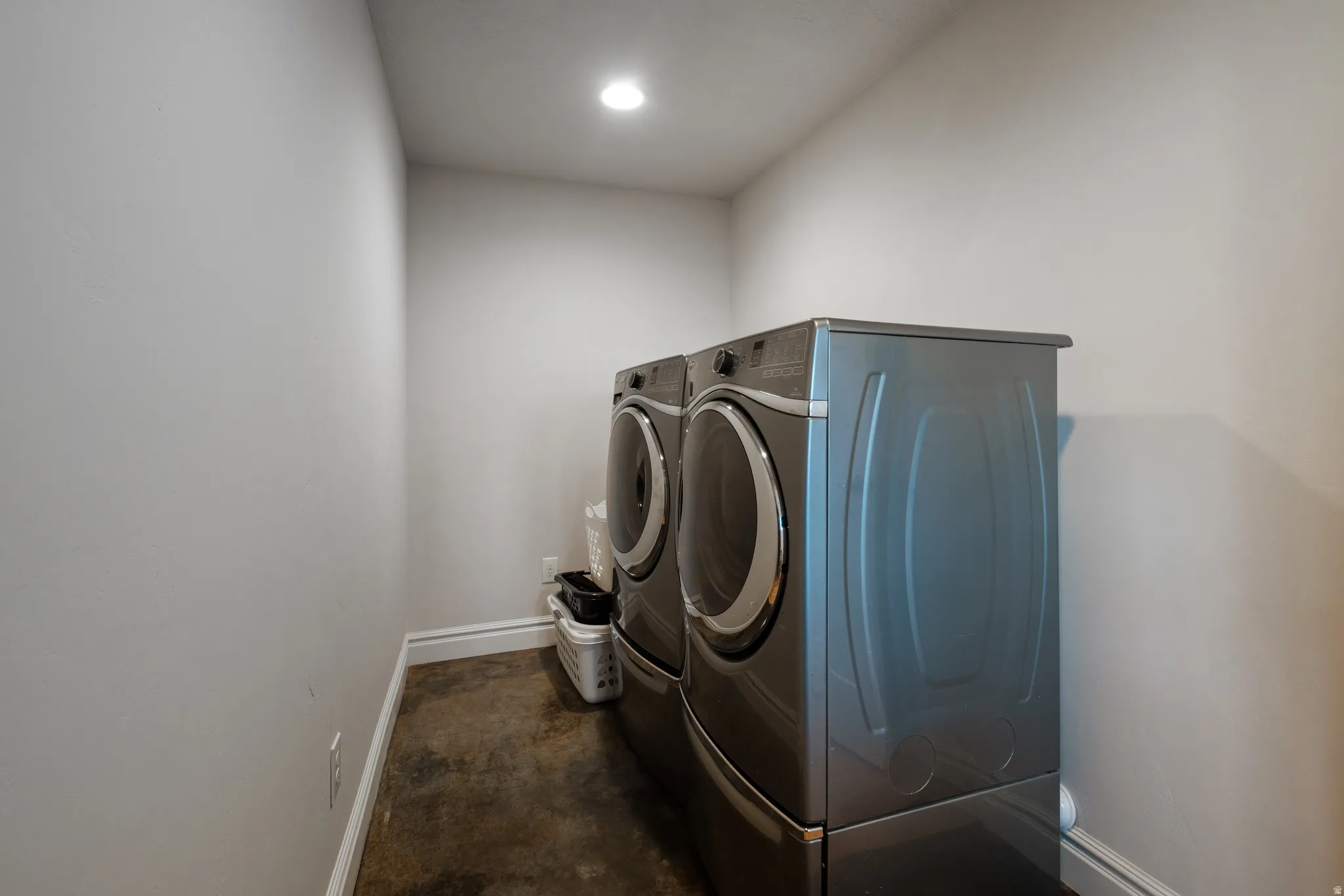 Dedicated laundry area with concrete flooring and recessed lighting