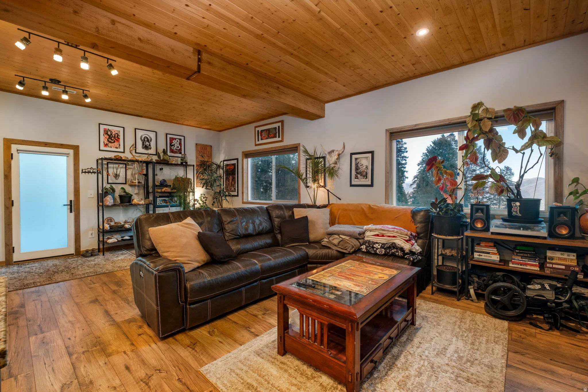 Living area featuring wood-finish flooring, a planked wood ceiling, recessed lighting, and large windows