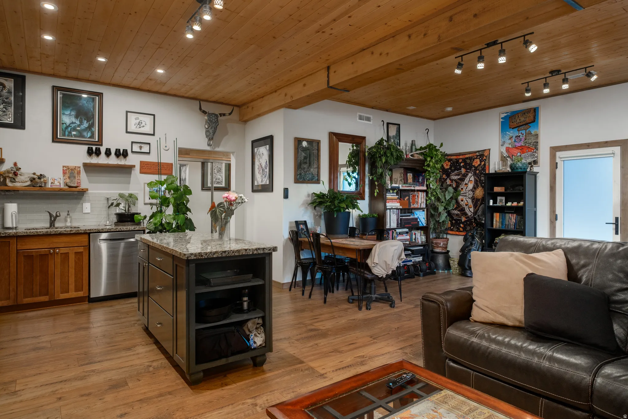 Open-concept living space with wood-finish flooring and a wood-paneled ceiling