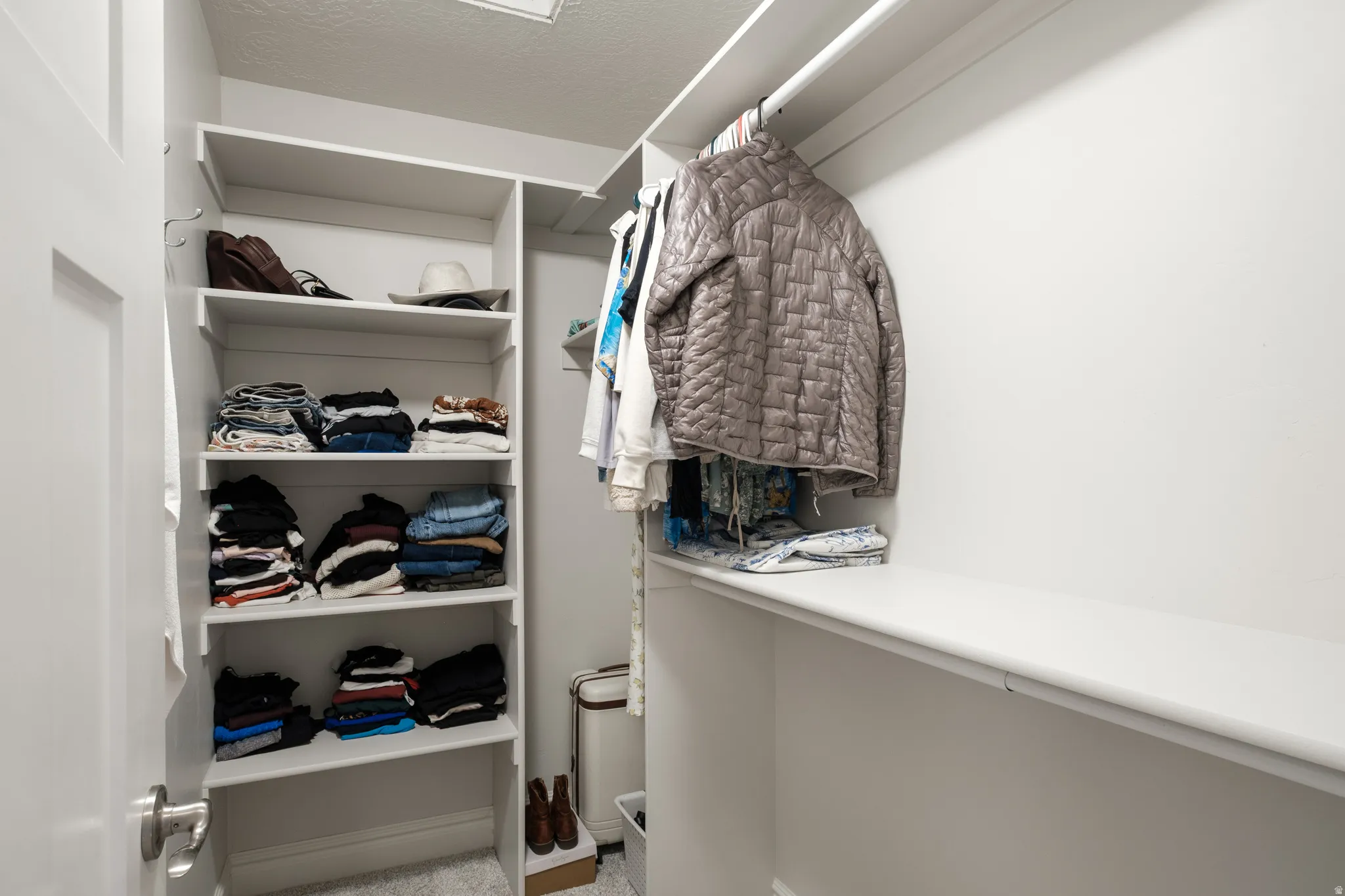 Custom closet system featuring built-in shelving, multiple hanging rods, and ample storage space