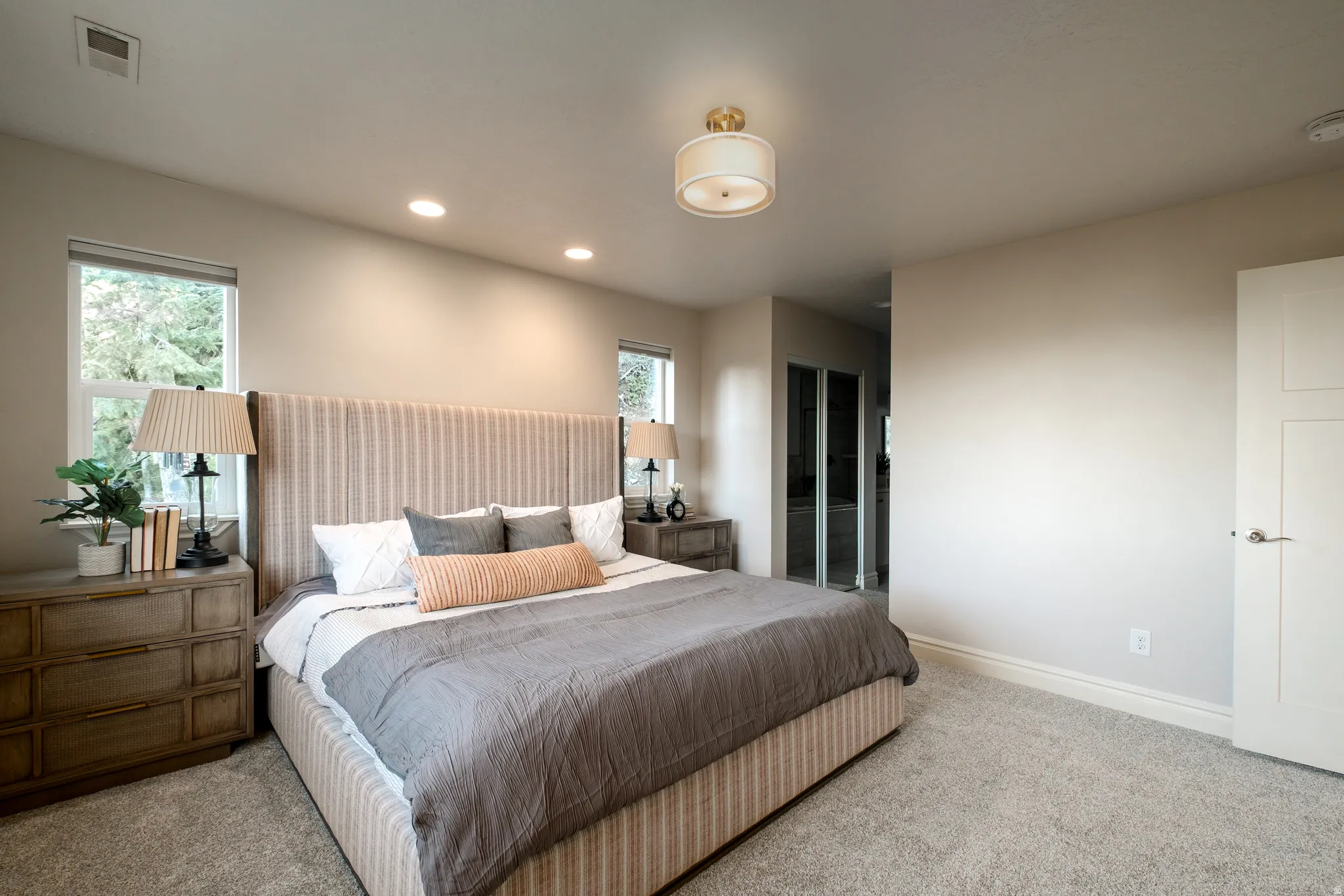 Carpeted bedroom with a vaulted ceiling, recessed lighting, and a contemporary flush mount light fixture