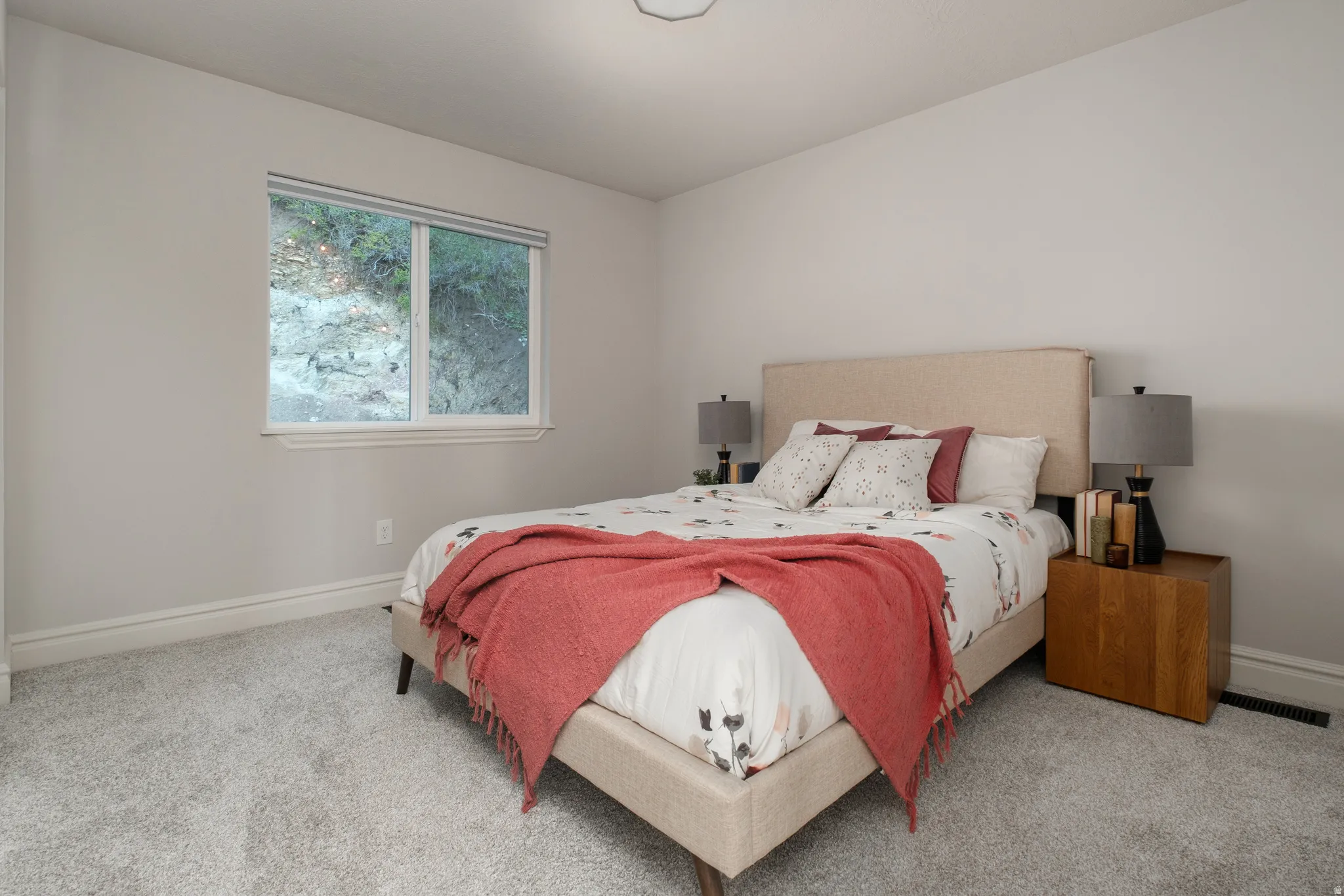 Carpeted bedroom with a window featuring white trim