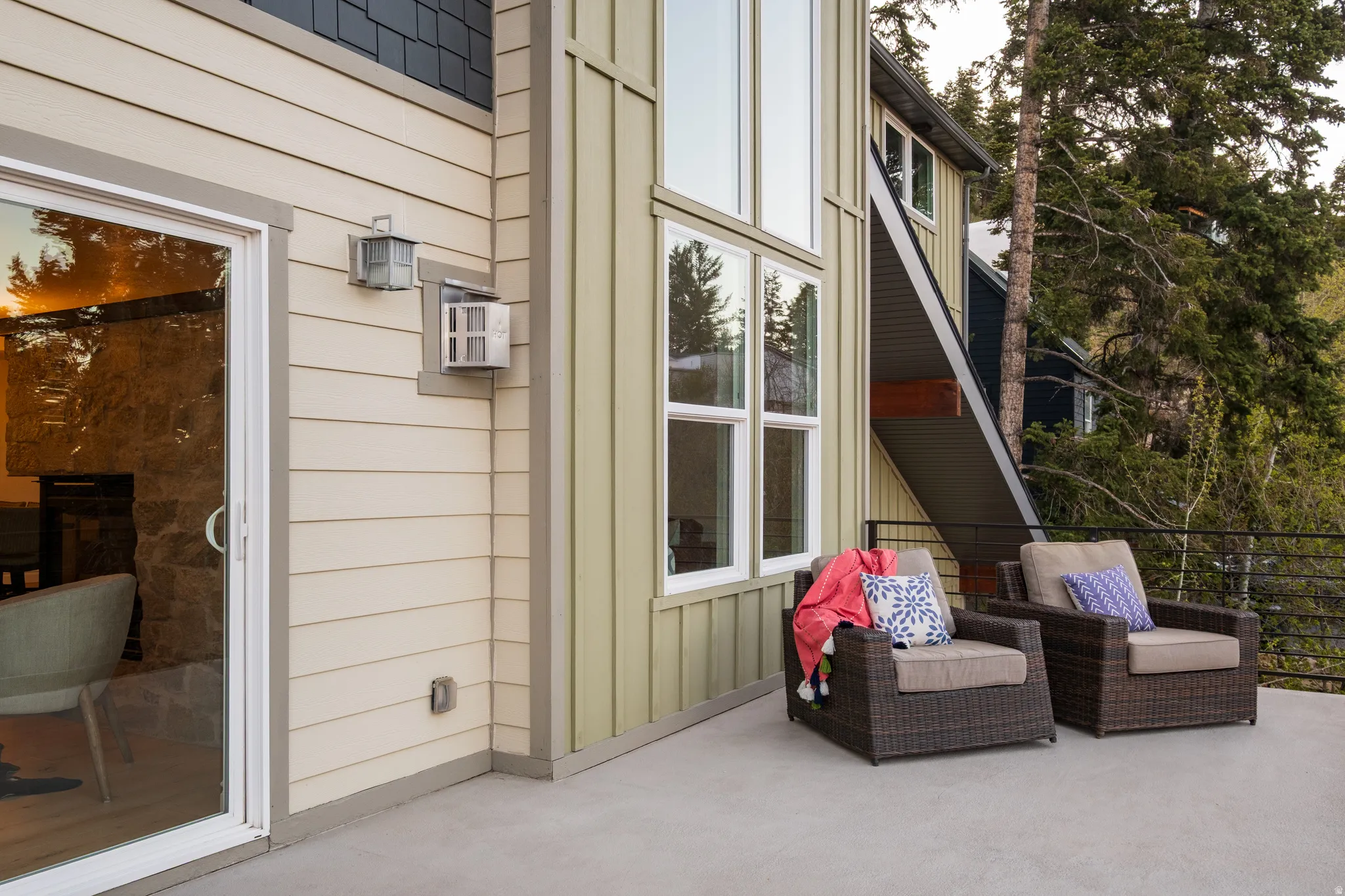 Spacious concrete patio with horizontal siding and vertical paneling exterior