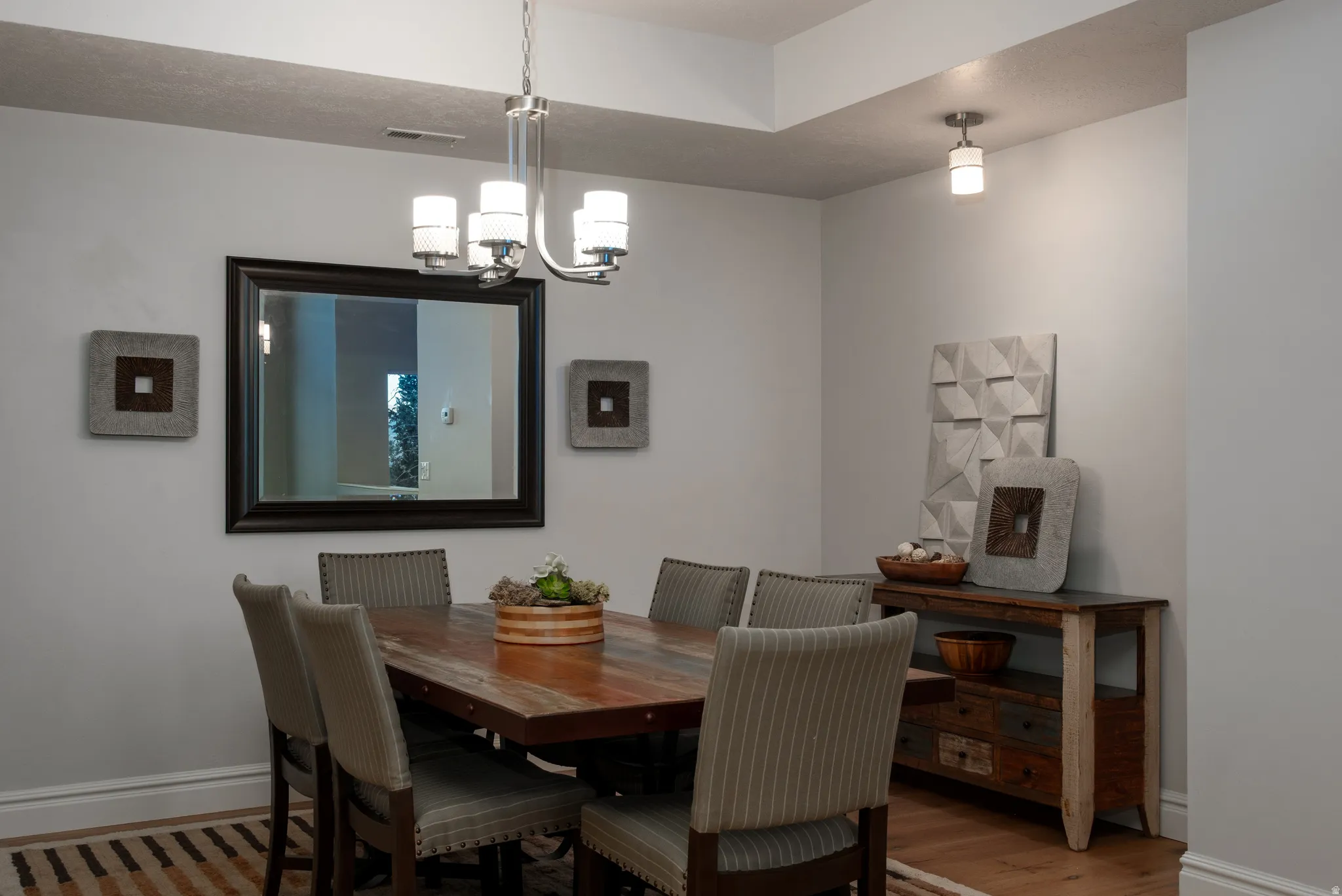 Dining area featuring a tray ceiling with recessed lighting and a contemporary chandelier