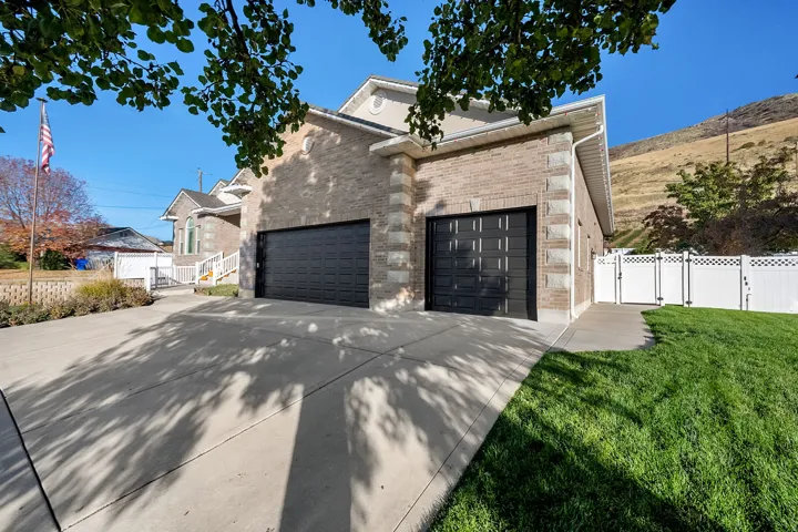 Brick and stone exterior featuring two black paneled garage doors