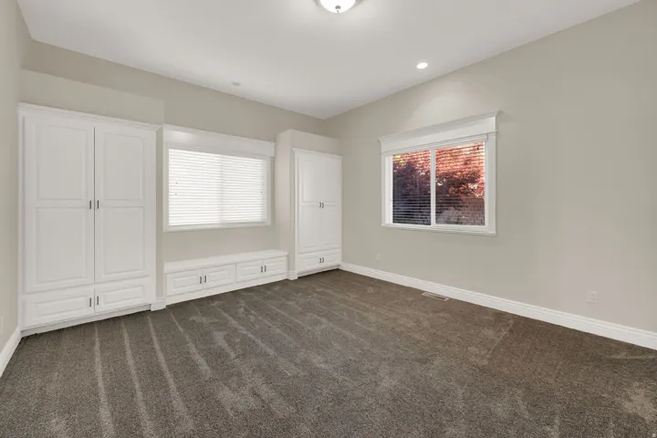 Neutral-toned room featuring a window with white blinds, recessed lighting, and a flush mount ceiling fixture