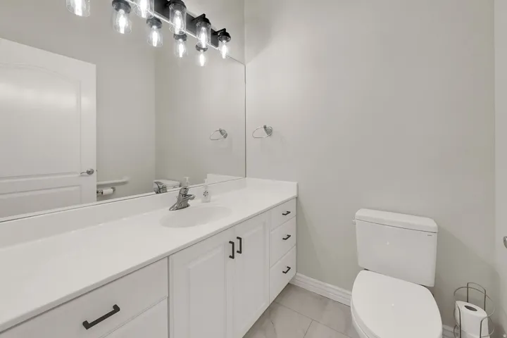Bathroom vanity featuring white cabinetry, a single basin sink, and a coordinating countertop