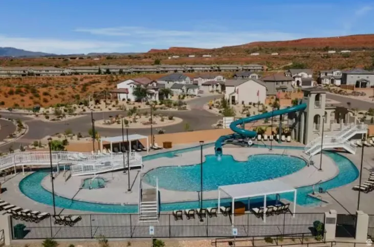 Expansive aquatic amenity featuring multiple pools, a winding lazy river, and a water slide tower