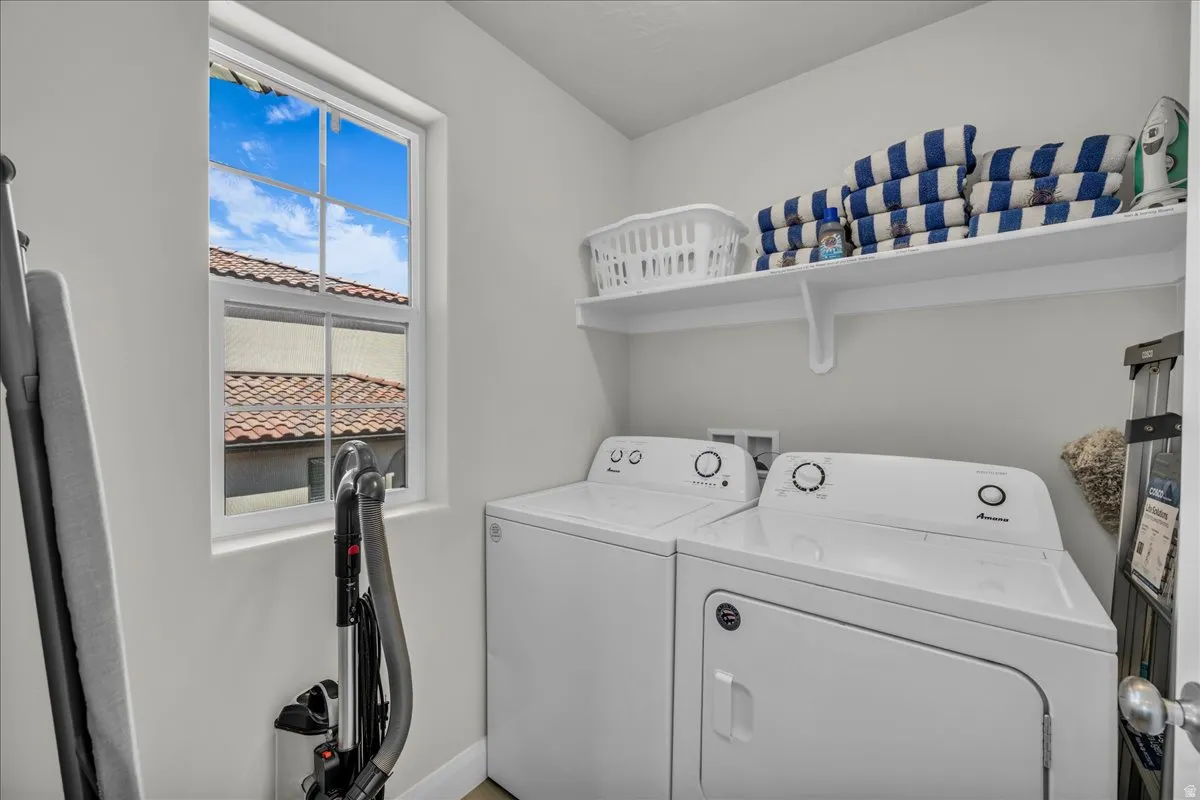 Laundry area featuring a window, built-in shelving, light gray wall paint, and wood-finish flooring