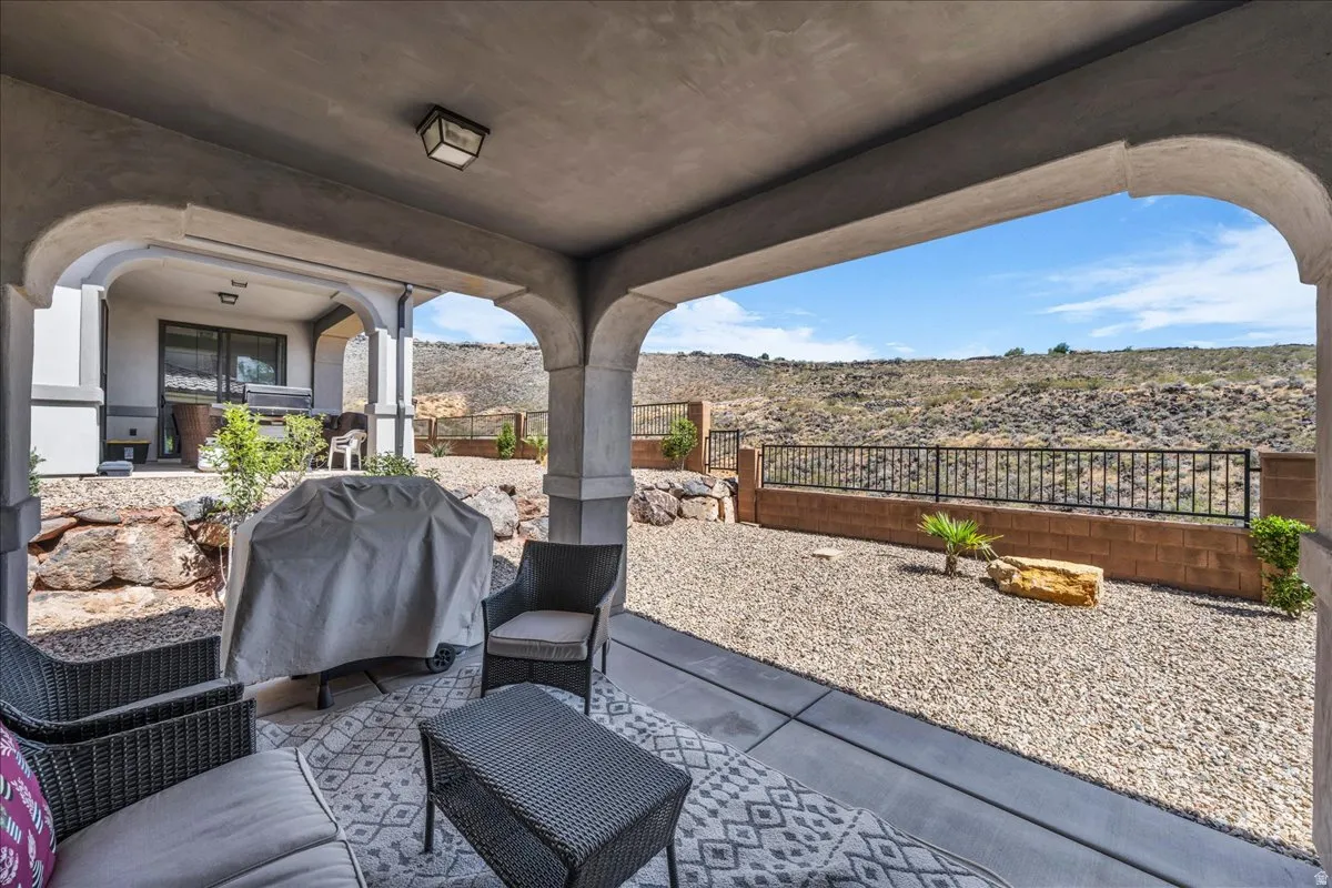 Covered patio with arched entryways, concrete flooring, and a ceiling-mounted light fixture