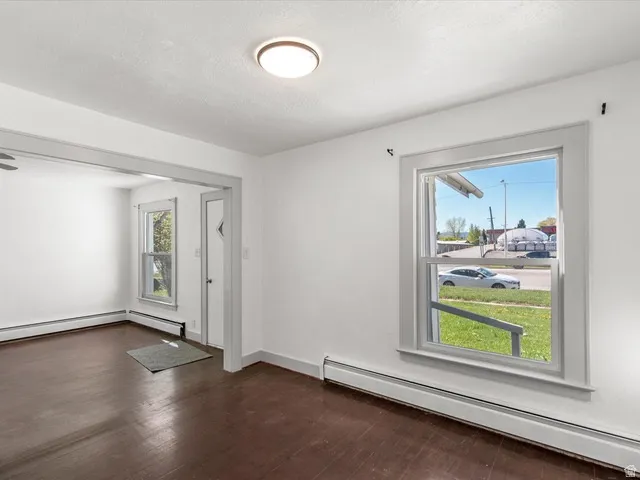 Interior space featuring dark wood-finish flooring, white walls, and a ceiling-mounted light fixture